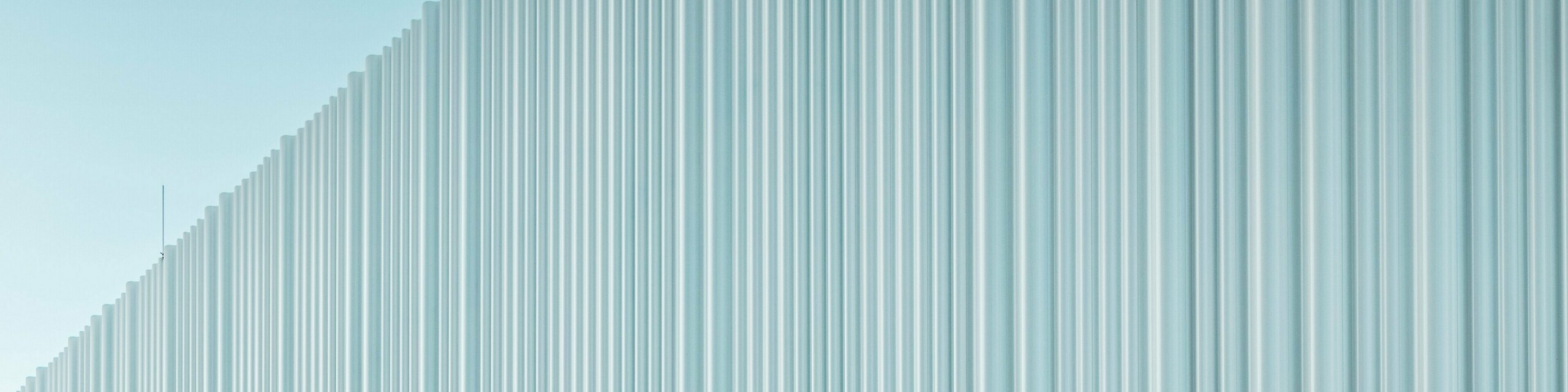 Une conception de façade spectaculaire avec le profil extrudé PREFA Sinus en aluminium de haute qualité habille le siège de l’entreprise LKW Walter à Vienne. La structure profilée, légèrement ondulée et disposée verticalement, crée un élégant effet de vagues générant de fascinants jeux de lumière. Alors que le bâtiment moderne séduit par son langage formel épuré, la découpe courbe de la façade apporte un contraste architectural fort et distinctif. Les profils en aluminium, durables et résistants à la corrosion, dotés d’une fixation invisible, garantissent une enveloppe extérieure haut de gamme et sans entretien.