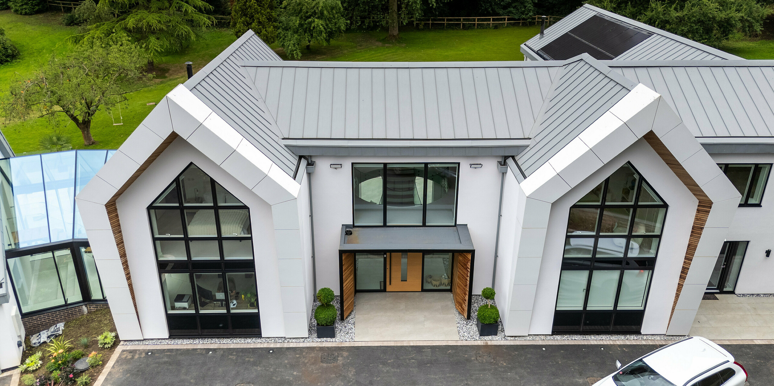 Cette impressionnante maison moderne à Draycott In The Clay met en valeur la remarquable toiture PREFALZ gris quartz, parfaitement intégrée à son environnement naturel. La toiture, avec son élégante construction à joints debout, se distingue par sa surface en aluminium durable et résistante à la corrosion, affirmant un style audacieux. De larges fenêtres et des lignes architecturales épurées offrent des vues imprenables sur la nature environnante, tandis que la toiture PREFALZ impressionne non seulement par son esthétique, mais assure également une protection optimale. Un parfait exemple de design moderne et durable utilisant les produits PREFALZ de haute qualité.
