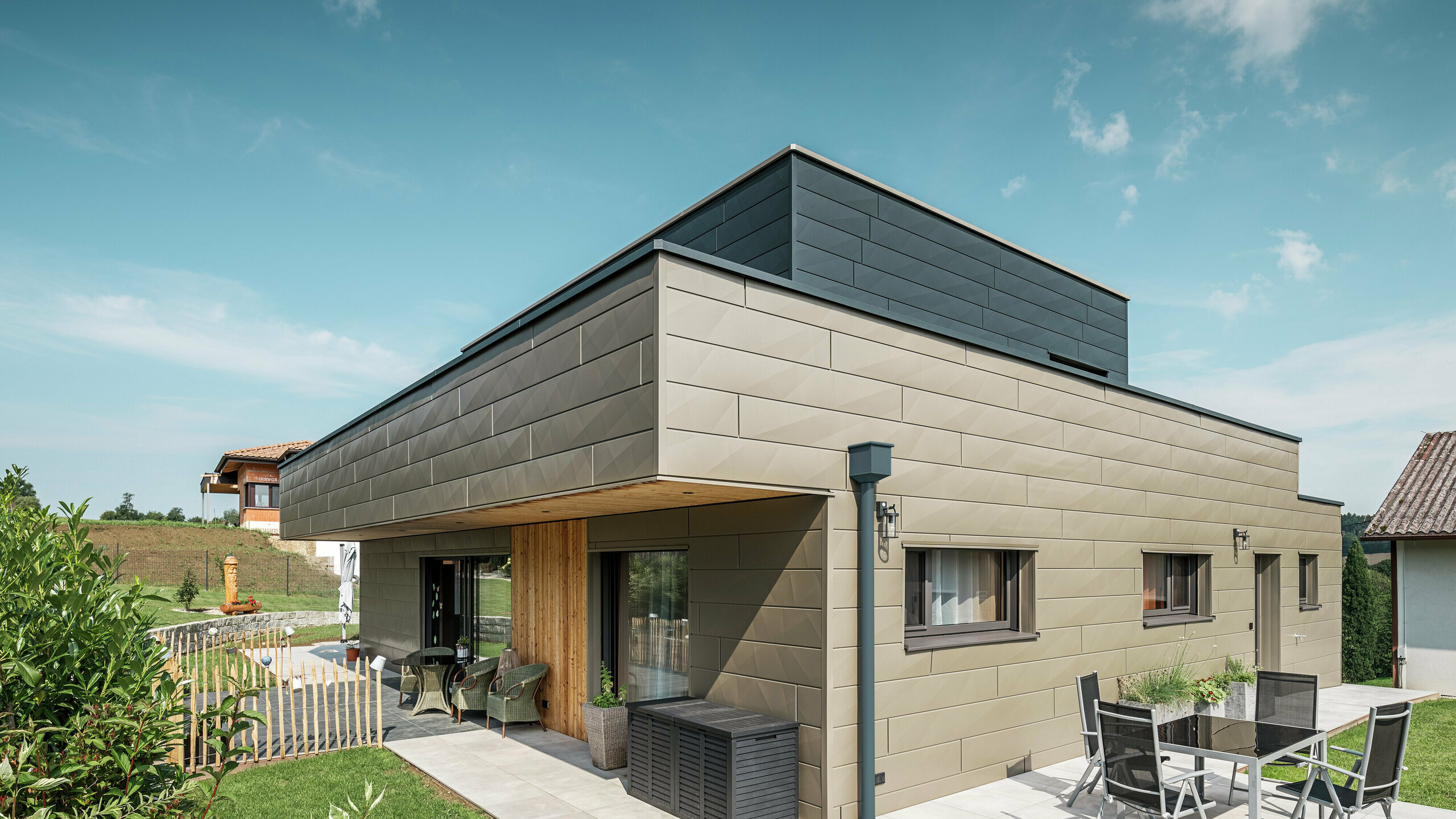 On peut voir une maison individuelle à Wippenham avec une façade bicolore en Siding.X dans les couleurs P.10 bronze Prefa et P.10 anthracite.