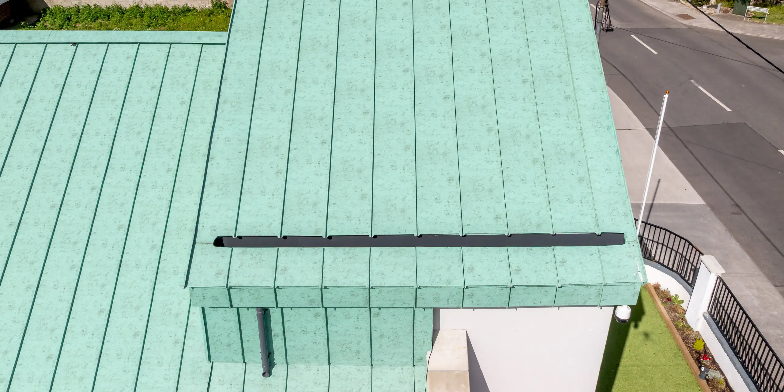 Détail de la remarquable toiture à joints debout en aluminium PREFALZ de l'église orthodoxe Saint-Thomas de Dublin. Les vastes surfaces de toiture, d'un P.10 vert de gris, définissent l'esthétique de l'édifice et attirent immédiatement le regard par leur aspect évoquant les toitures en cuivre d'antan. La précision des joints souligne la pureté des lignes architecturales et confère à la toiture une structure élégante. L'aluminium PREFA, de haute qualité, impressionne par sa durabilité, sa résistance à la corrosion, sa légèreté et son excellente tenue des couleurs – un matériau idéal pour une architecture raffinée au charme intemporel.