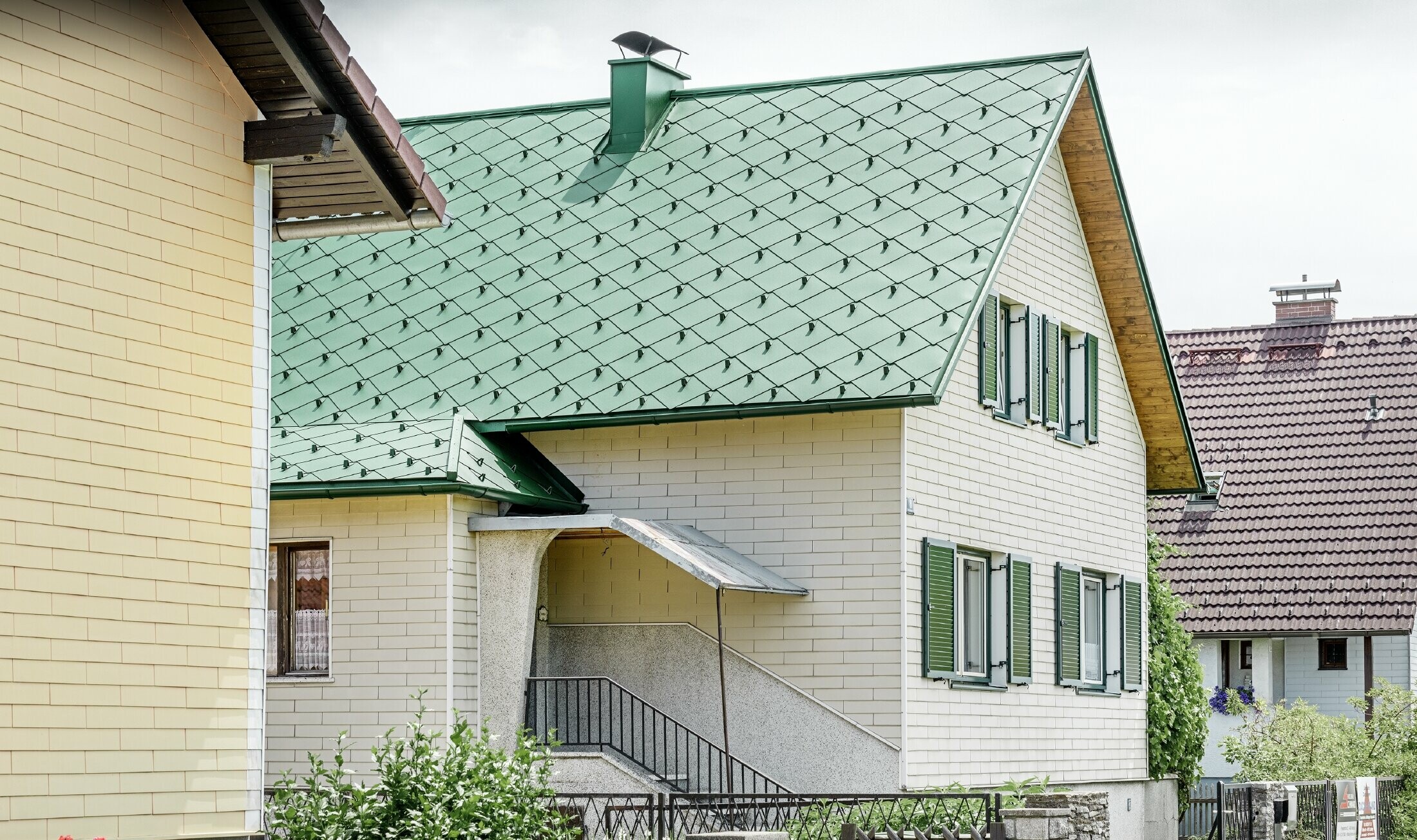 Maison individuelle classique au toit à deux versants dotée de volets verts — Couverture de toit en aluminium de couleur vert mousse