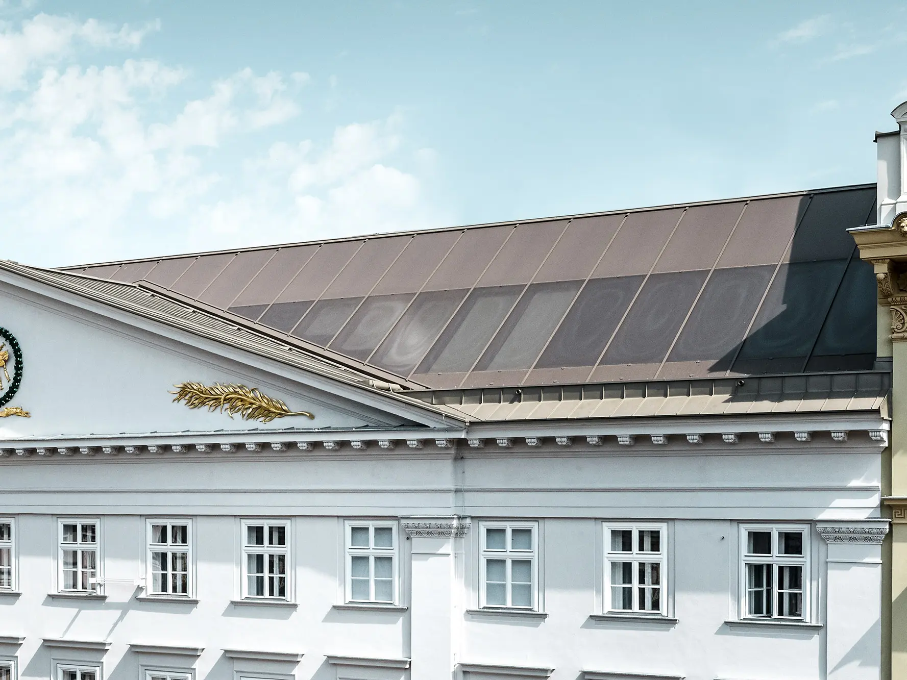 Vue rapprochée d’une partie de la façade et de la toiture Prefalz, avec les vitrages sérigraphiés.