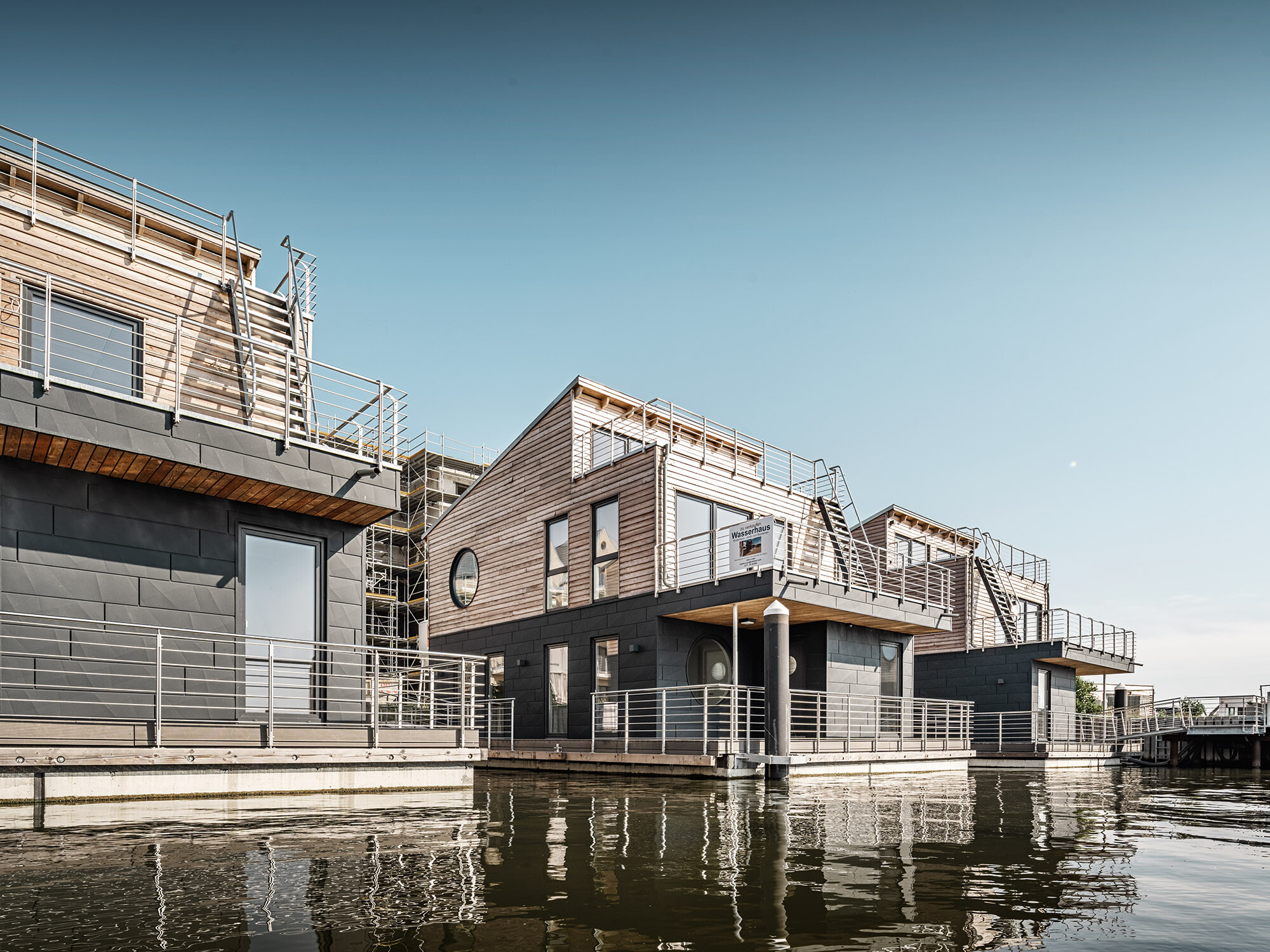 Les maisons aquatiques de Schleswig en contre-plongée, avec une séparation apparente grâce à leur façade en bois et en aluminium.
