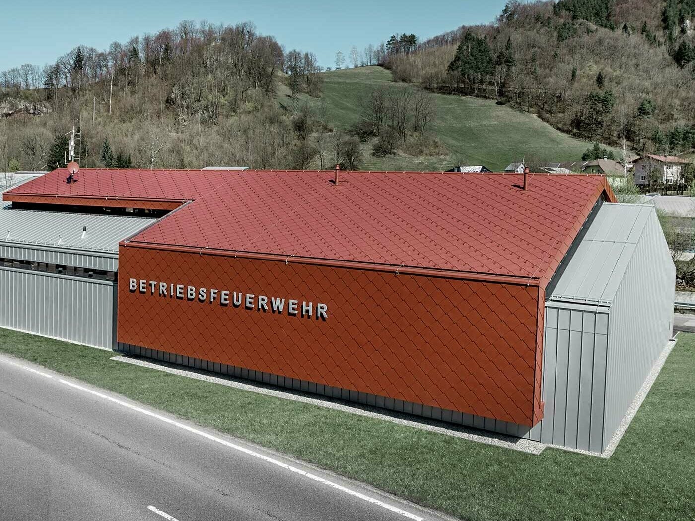 La nouvelle caserne des sapeurs-pompiers des entreprises PREFA et Neuman Aluminium a été habillée des nouveaux losanges de toiture et de façade 44 × 44 couleur P.10 rouge oxyde ainsi que de Prefalz argent métallisé.