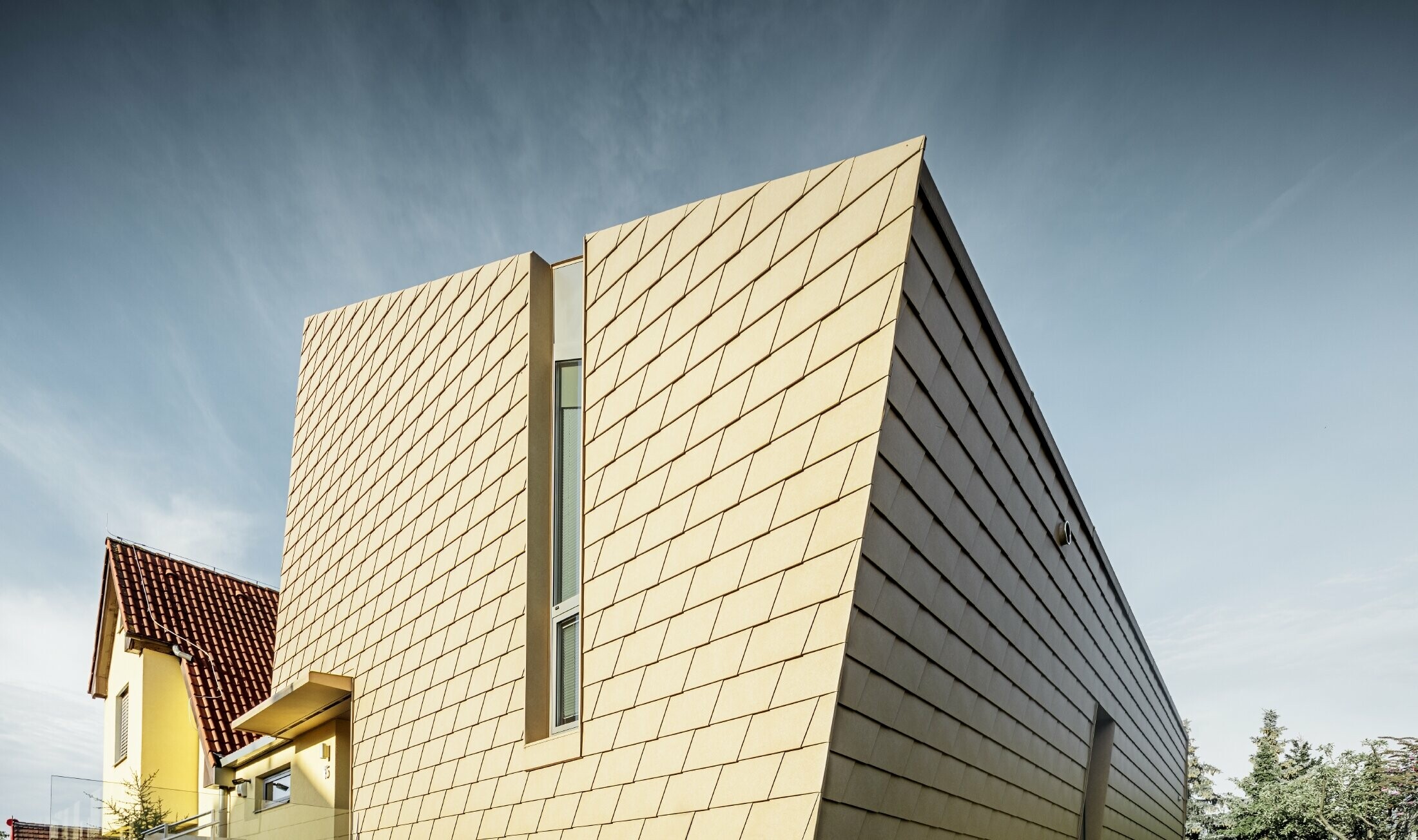Extension hors du commun sans avancée de toit avec une façade en aluminium de PREFA couleur brun sable ;