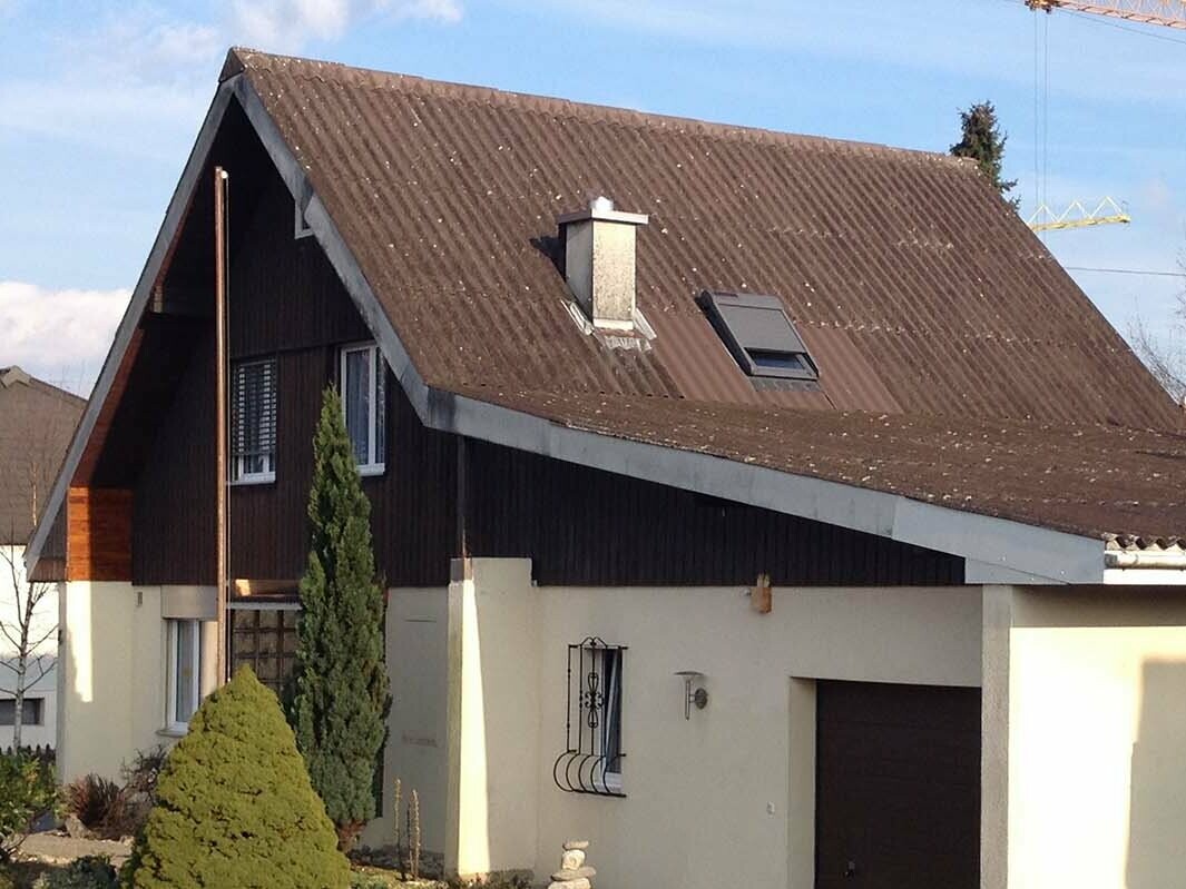 Maison avant la rénovation de toiture à l’aide de tuiles PREFA, toit à deux pans et garage