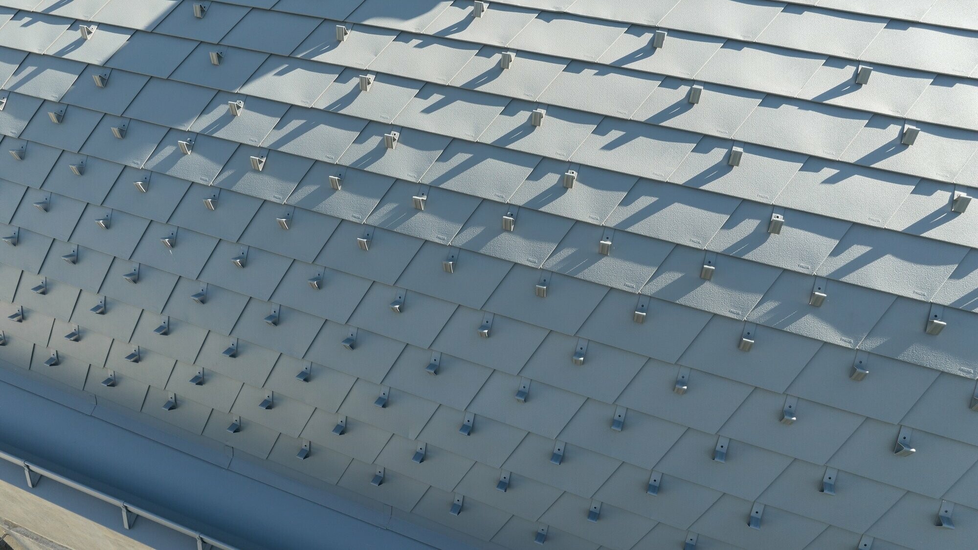 Vue rapprochée de la nouvelle toiture en bardeau PREFA dans la teinte P.10 gris souris stucco