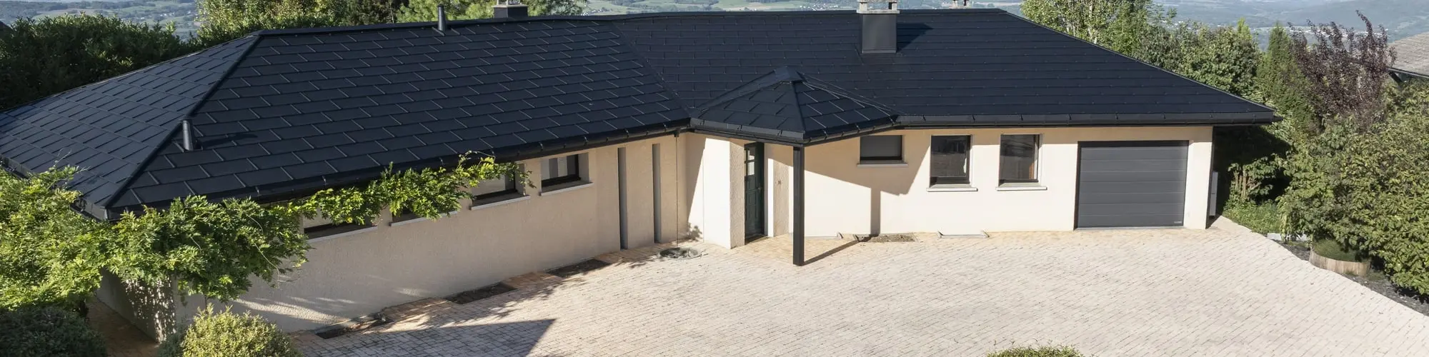 Vue d'ensemble de cette maison individuelle récemment rénovée avec les produits en aluminium PREFA : gouttière demi-ronde, R.16 et joint debout Prefalz en P.10 noir