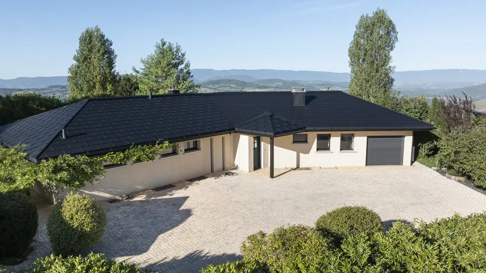 Vue d'ensemble de cette maison individuelle récemment rénovée avec les produits en aluminium PREFA : gouttière demi-ronde, R.16 et joint debout Prefalz en P.10 noir