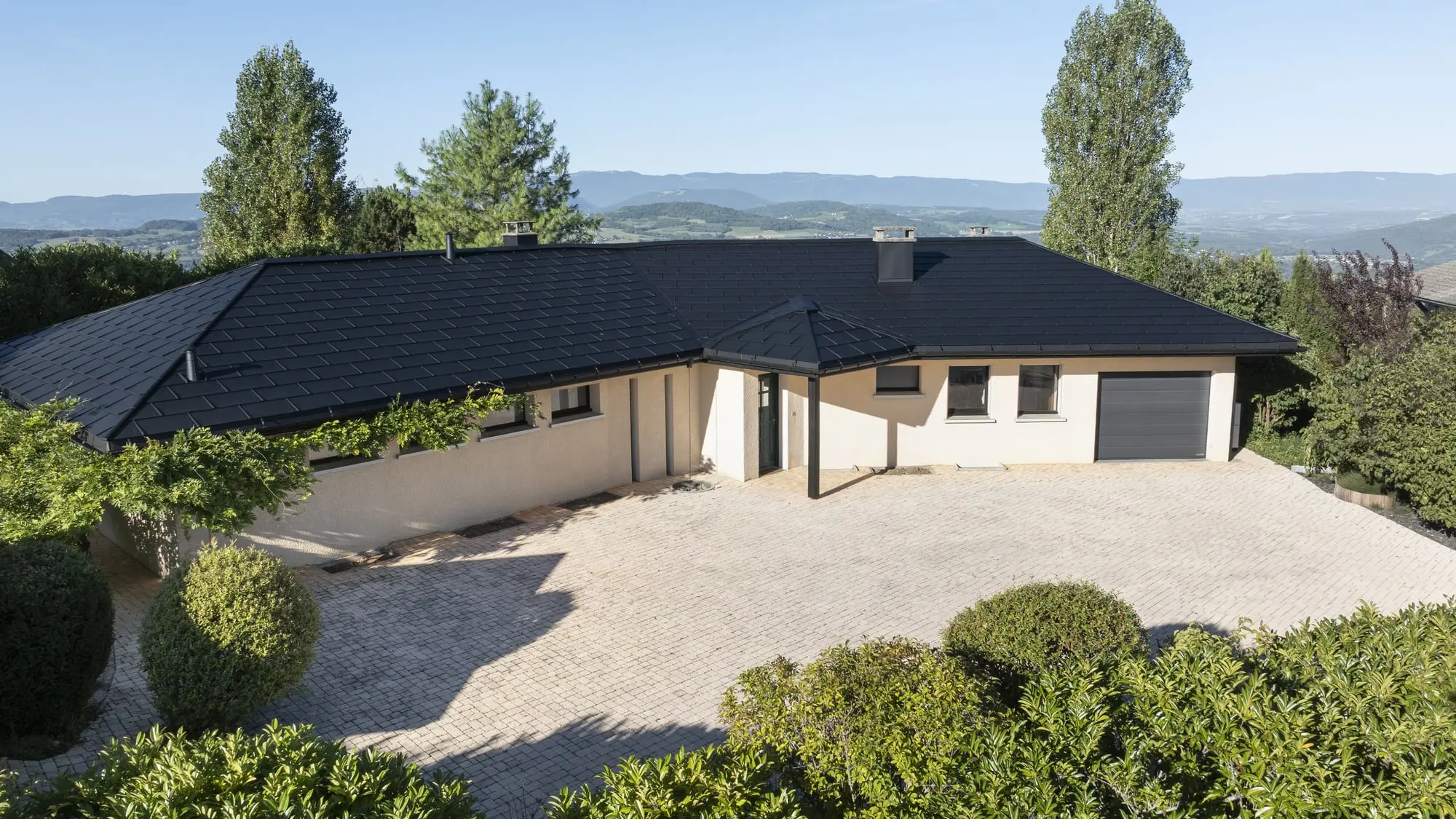 Vue d'ensemble de cette maison individuelle récemment rénovée avec les produits en aluminium PREFA : gouttière demi-ronde, R.16 et joint debout Prefalz en P.10 noir