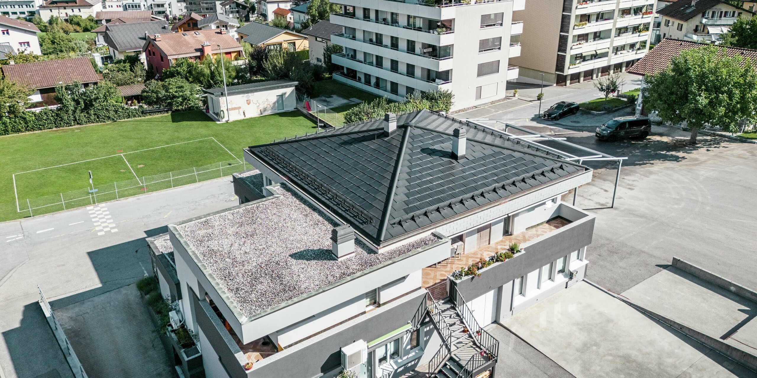 Le toit moderne de la cave Leukersonne à Susten (CH) avec tuiles solaires PREFA et R.16 en P.10 noir - durable, résistant aux intempéries et économe en énergie.