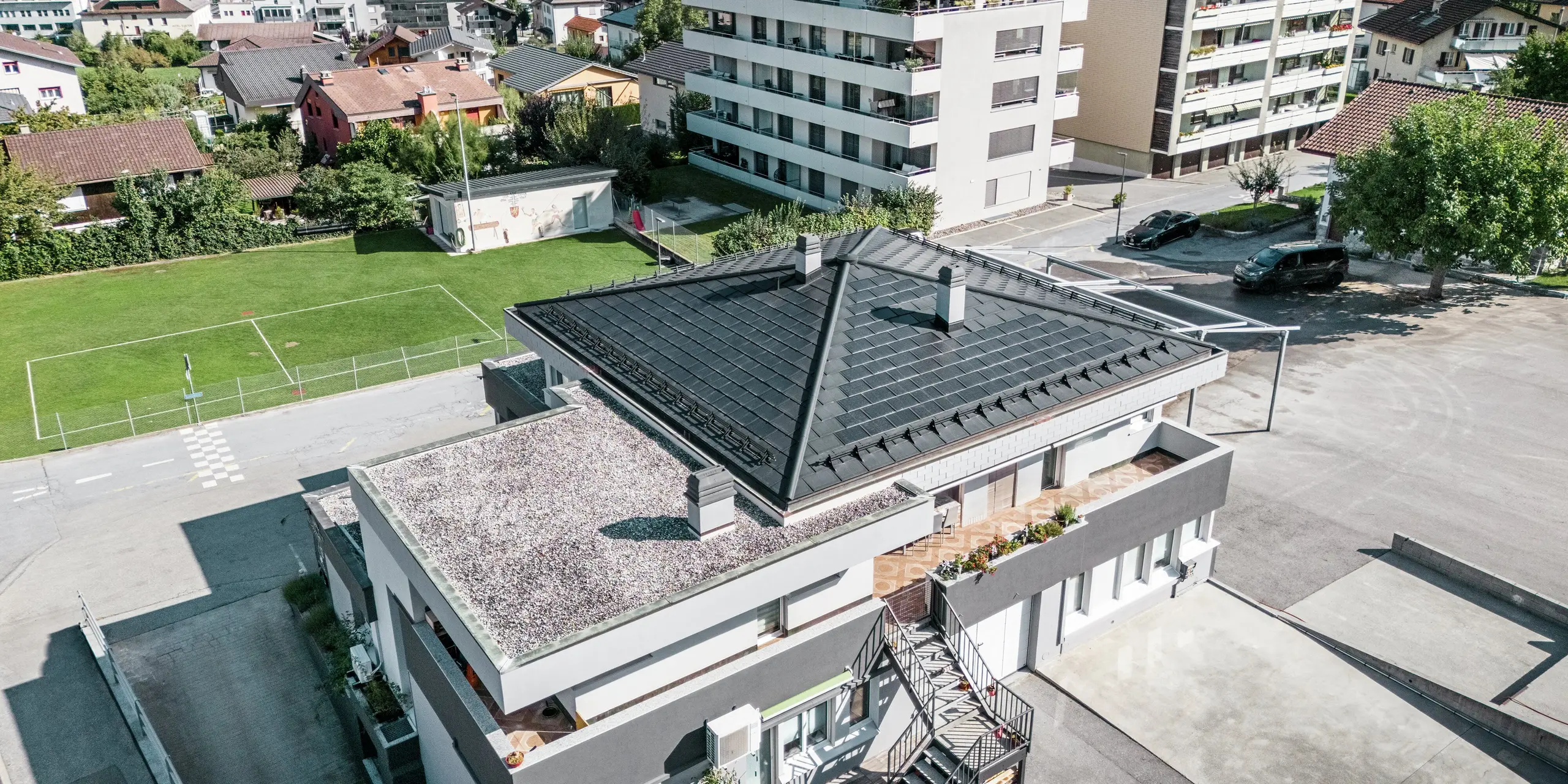 Le toit moderne de la cave Leukersonne à Susten (CH) avec tuiles solaires PREFA et R.16 en P.10 noir - durable, résistant aux intempéries et économe en énergie.