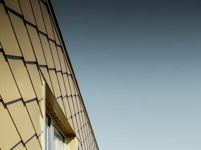 Extravagante Lösung für einen Wiener Dachgeschossausbau mit PREFA Rauten in Perlgold