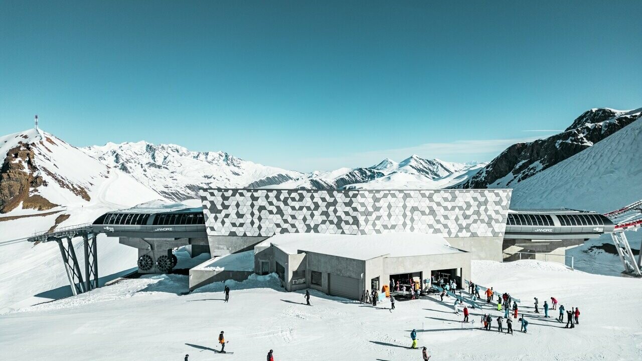 Vue d'une des stations du nouveau téléphérique Le Jandri de la station Les 2 Alpes, recouverte de panneaux composites en aluminium PREFABOND façonné en losanges de trois couleurs différentes : blanc Prefa, blanc pur et argent fumé.