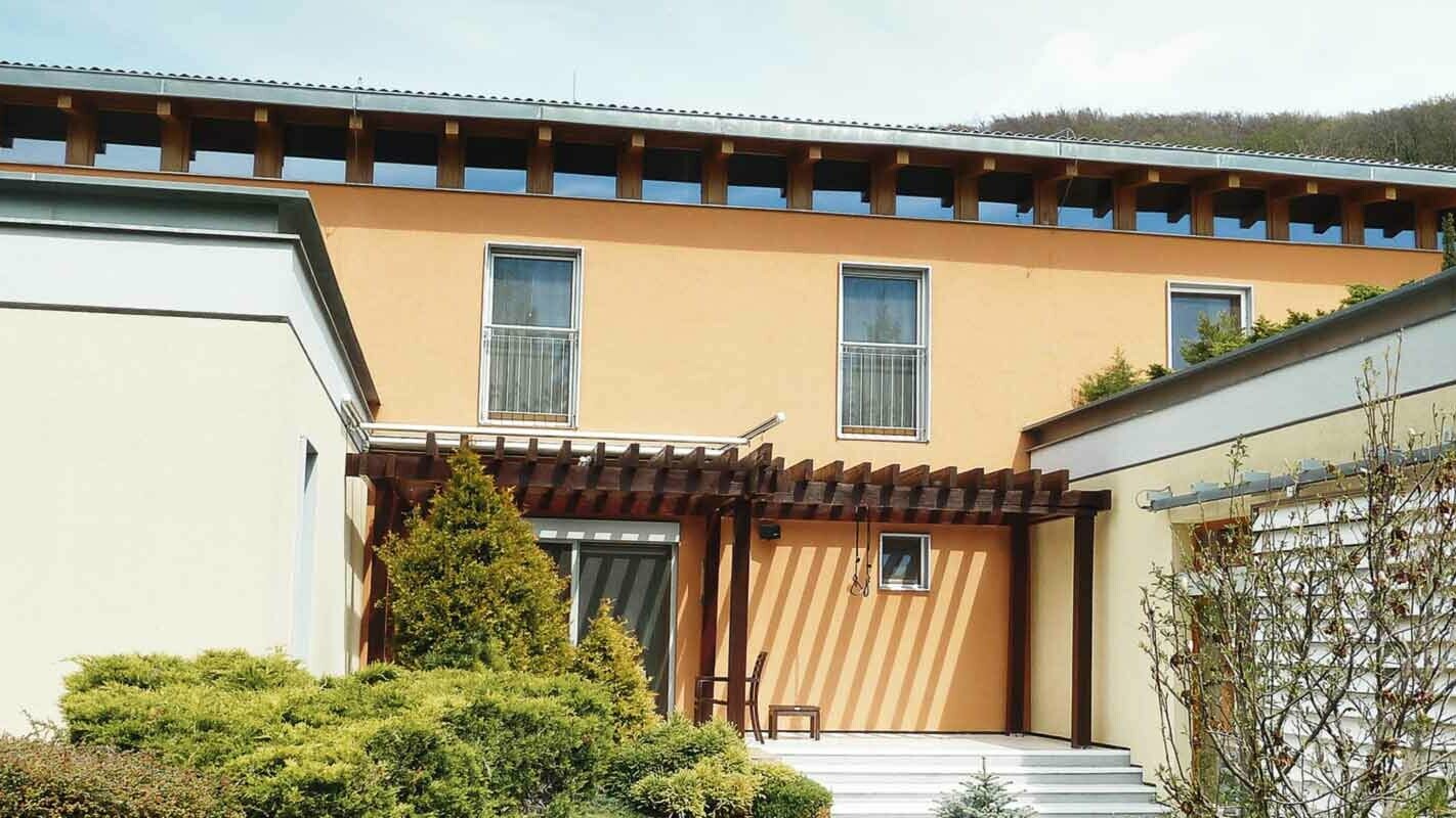 Maison individuelle moderne avant la rénovation de façade à l’aide de panneaux de façade FX.12 PREFA couleur P.10 anthracite, façade orange