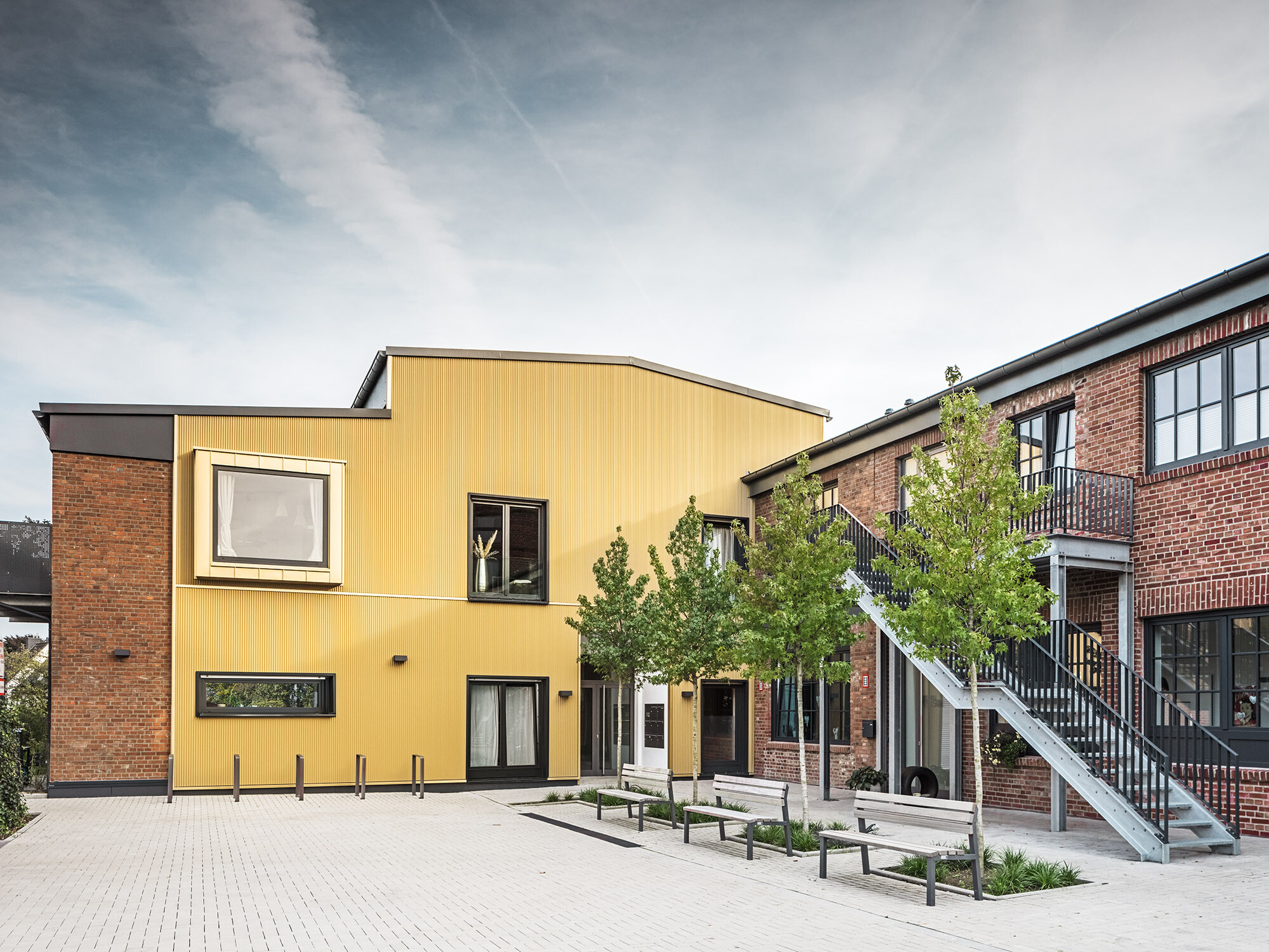 Un coup d'œil sur le site des Kellerhöfe avec les façades en briques et en aluminium de l'ancien bâtiment de l'usine.