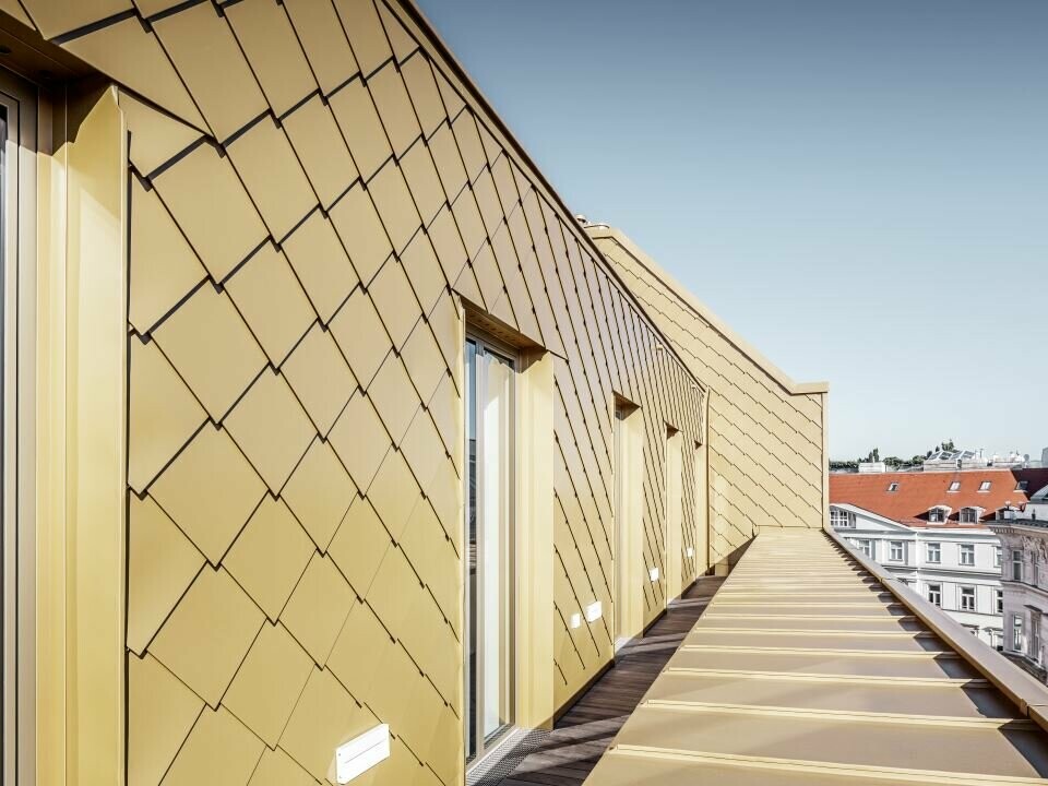 Seitliche Ansicht des Dachgeschossausbaus mit PREFA Rauten 29 × 29 in Perlgold