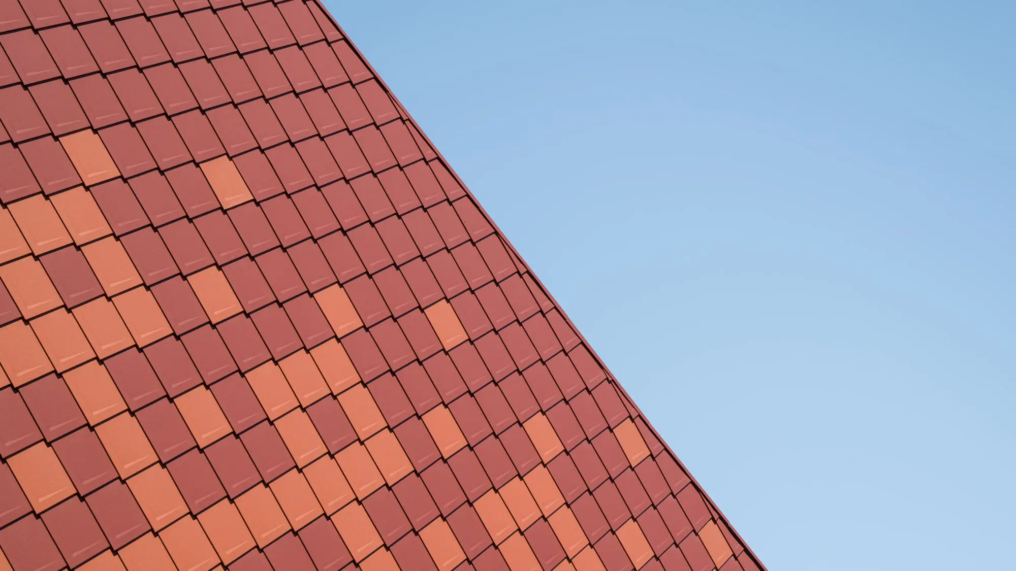 Vue latérale de la salle polyvalente rénovée dont le pignon arbore fièrement les losanges PREFA