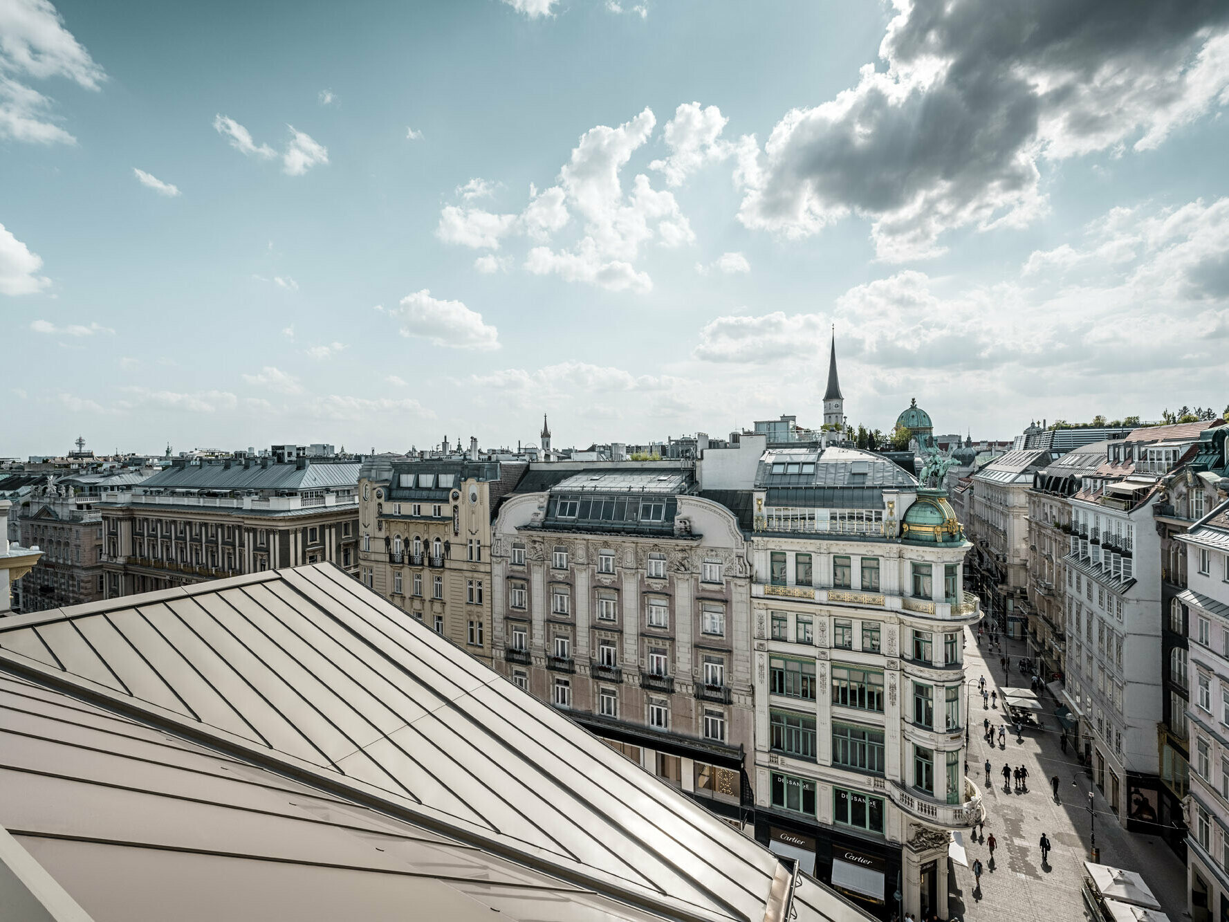 Vue large sur les toits de Vienne, avec à gauche les bandes Prefalz à l’élégante couleur bronze de l’hôtel Rosewood Vienna.