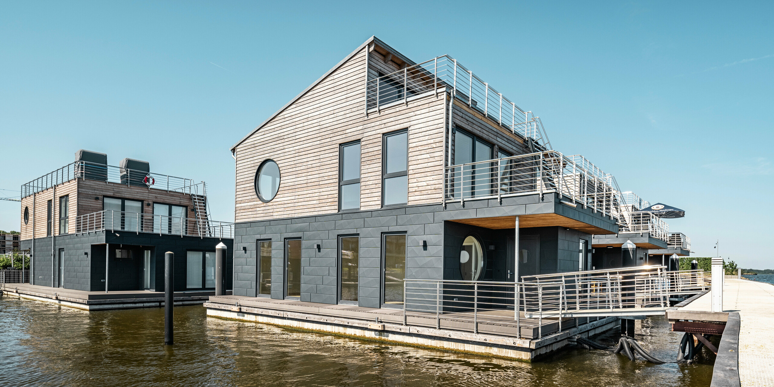 La façade en aluminium Siding.X PREFA entoure onze maisons flottantes dans le port pionnier du Schleswig.