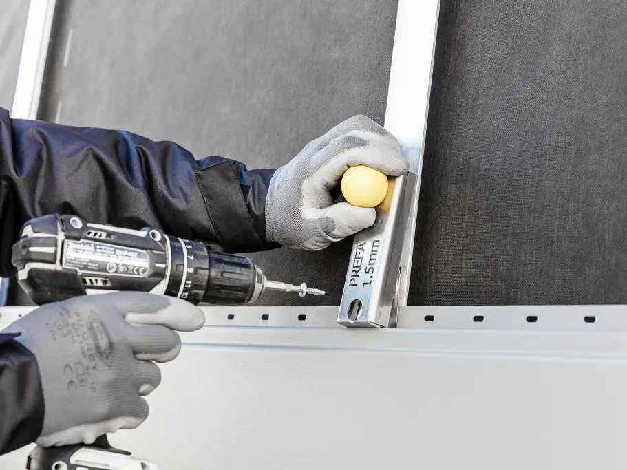 Zoom sur un artisan en train d'installer une lame de Siding sur la façade.