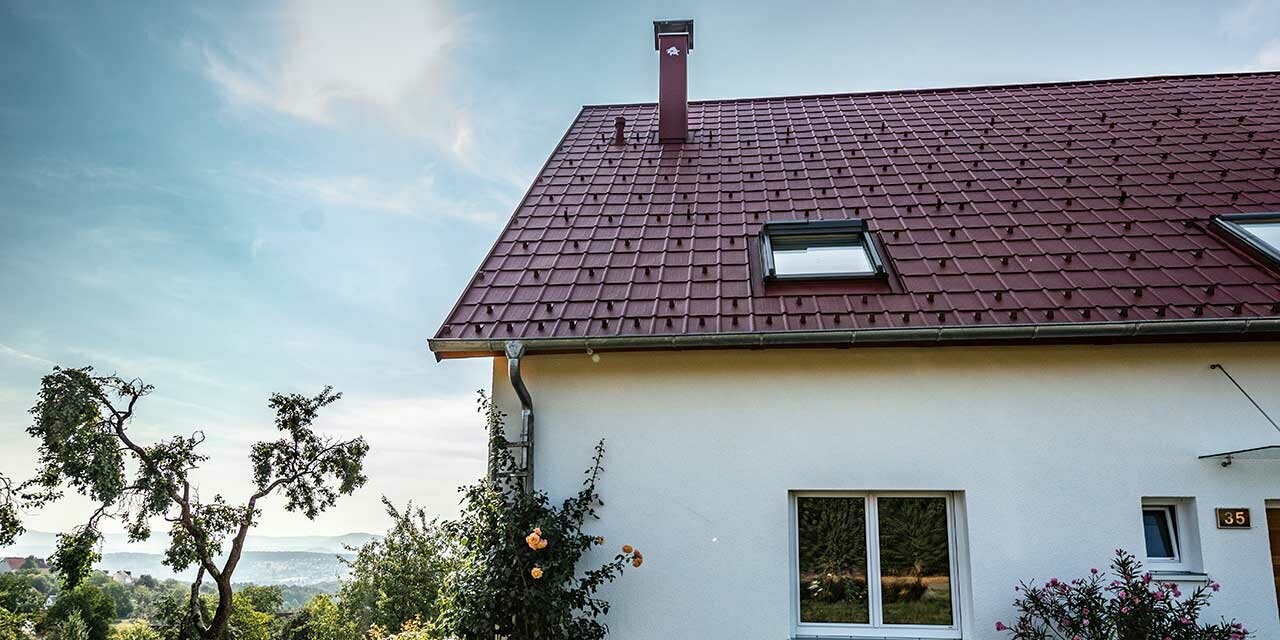 Maisonnette à la campagne, toiture rénovée avec tuile PREFA couleur rouge oxyde, fenêtres de toit et abergement de cheminée.