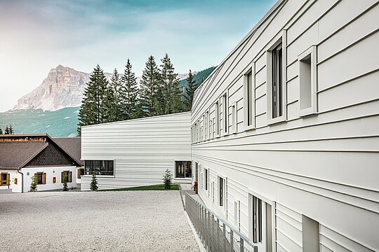 Une lumière claire, des lignes nettes : la façade de la caserne « Tempesti » dans le Tyrol du Sud montre de manière impressionnante comment un design moderne s'intègre dans un paysage montagneux. Les panneaux horizontaux PREFALZ dans la couleur P.10 blanc Prefa reflètent la lumière du soleil, améliorent le microclimat et convainquent par leur qualité robuste et durable. Ils sont un exemple fort d'architecture militaire bien pensée avec de l'aluminium.