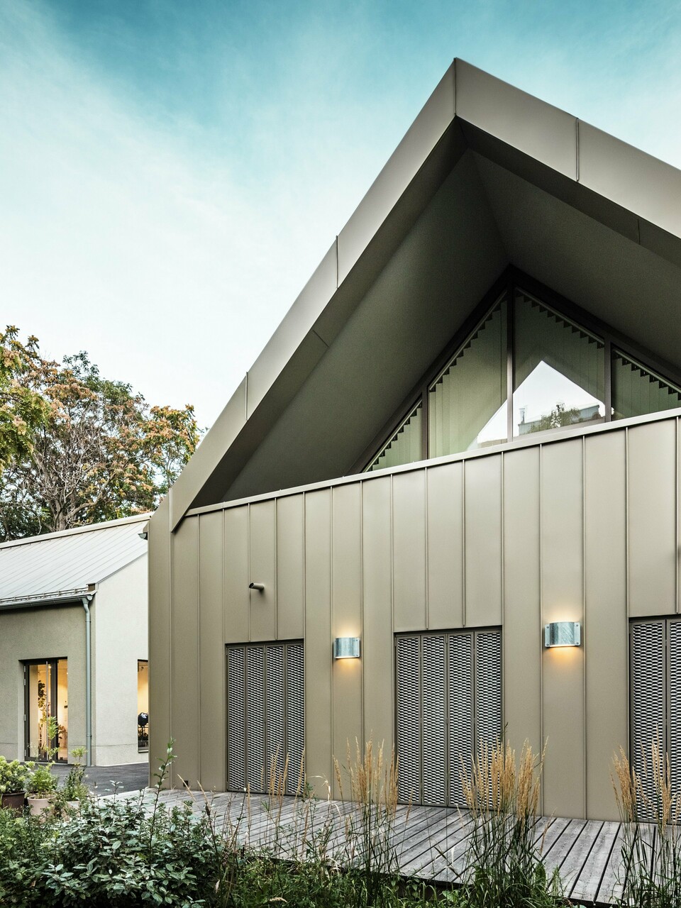 Vue de face du Studio Comploj à Vienne avec une façade en aluminium PREFALZ en P.10 bronze Prefa. L'atelier de soufflage de verre moderne allie artisanat et architecture contemporaine.