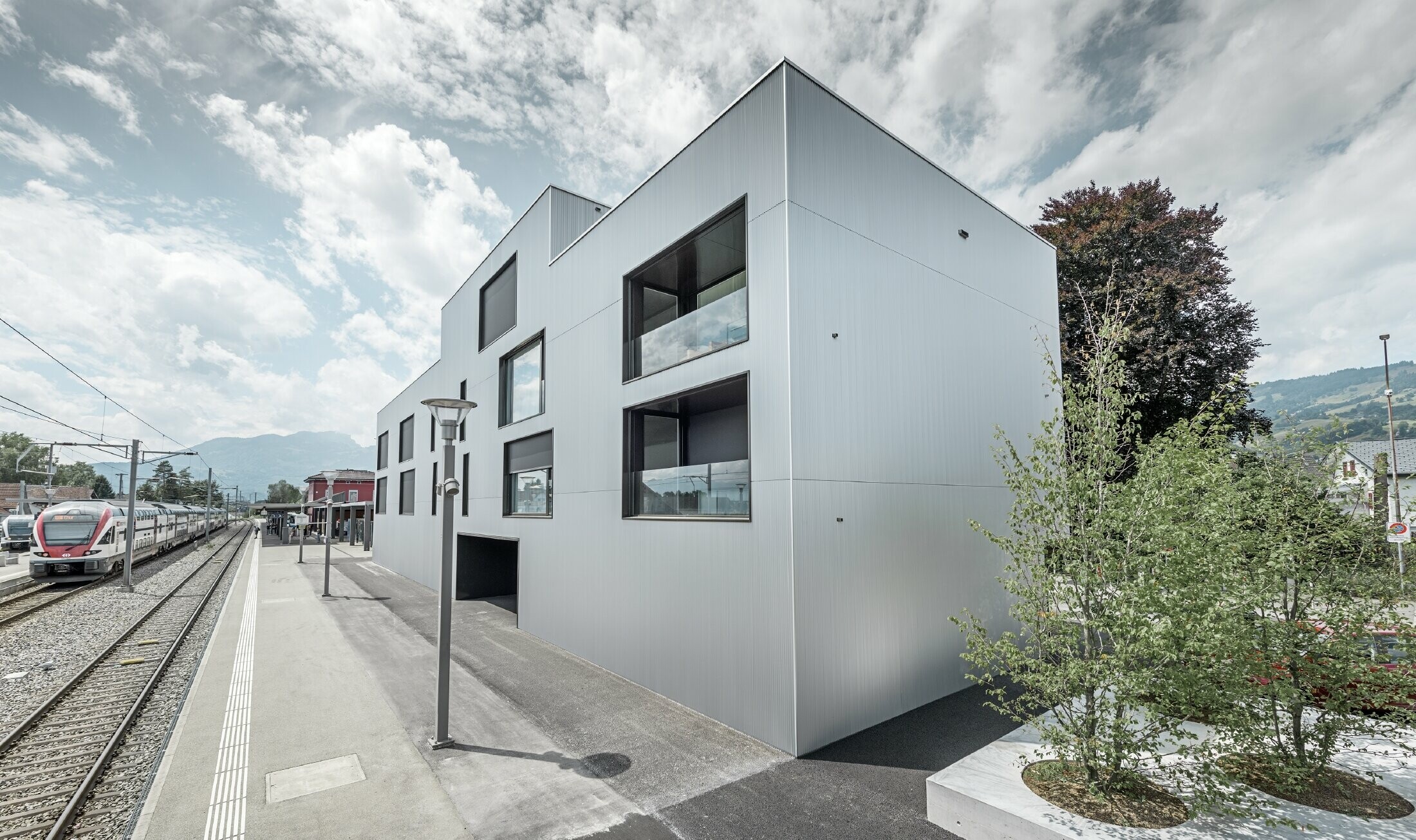 Bâtiment de société moderne à toit plat et façade alu ; pour la façade, le choix s’est porté sur le profil triangle PREFA anodisé naturel.