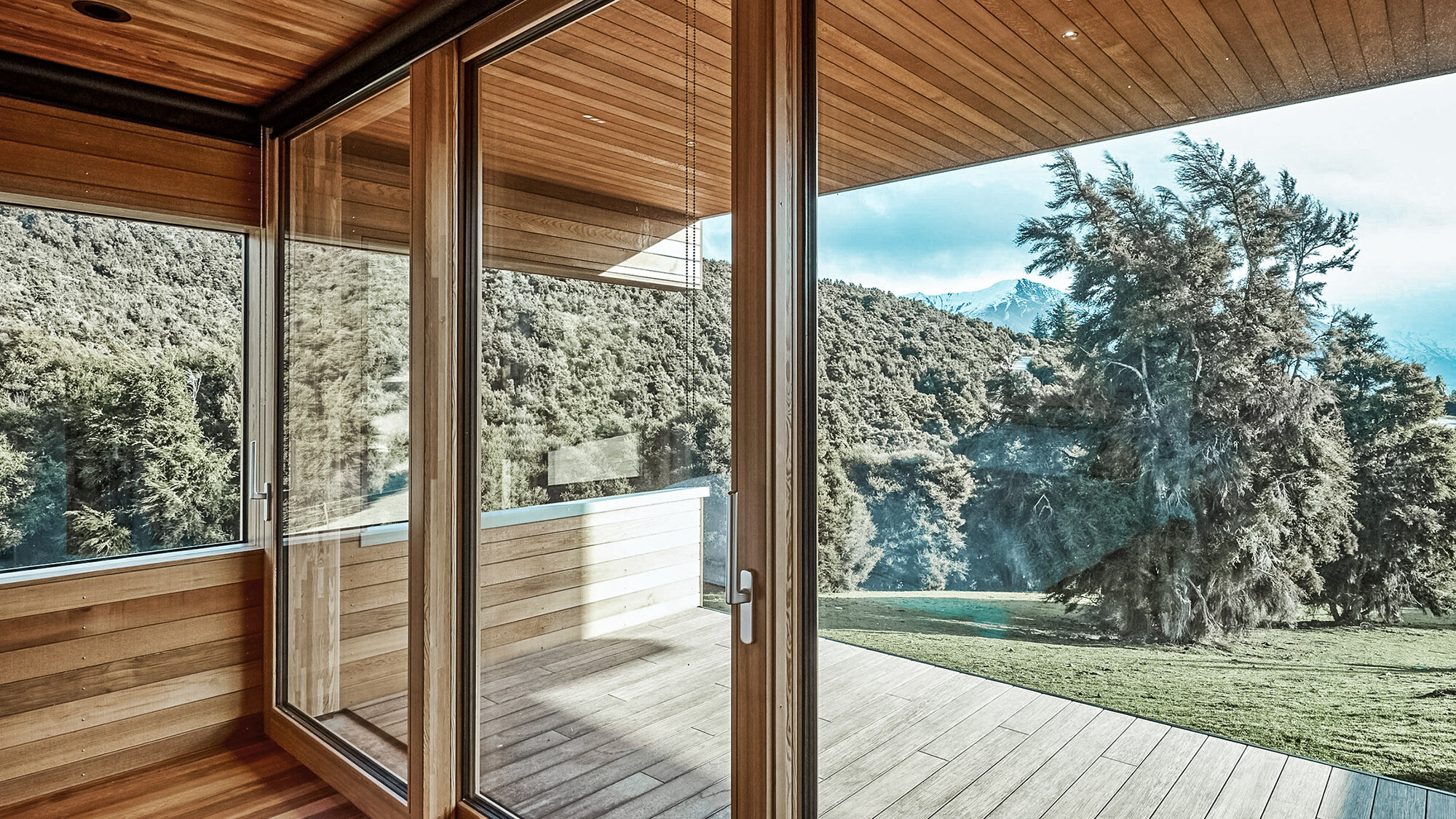 Blick auf die gewaltige Naturkulisse des Kanuka Valley durch die Fensterfront.