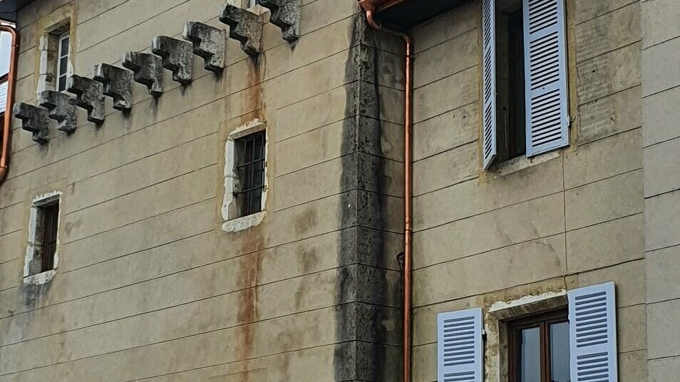 Vue depuis l'entrée du château où l'on aperçoit une partie du toit de la tourelle en bardeaux PREFA