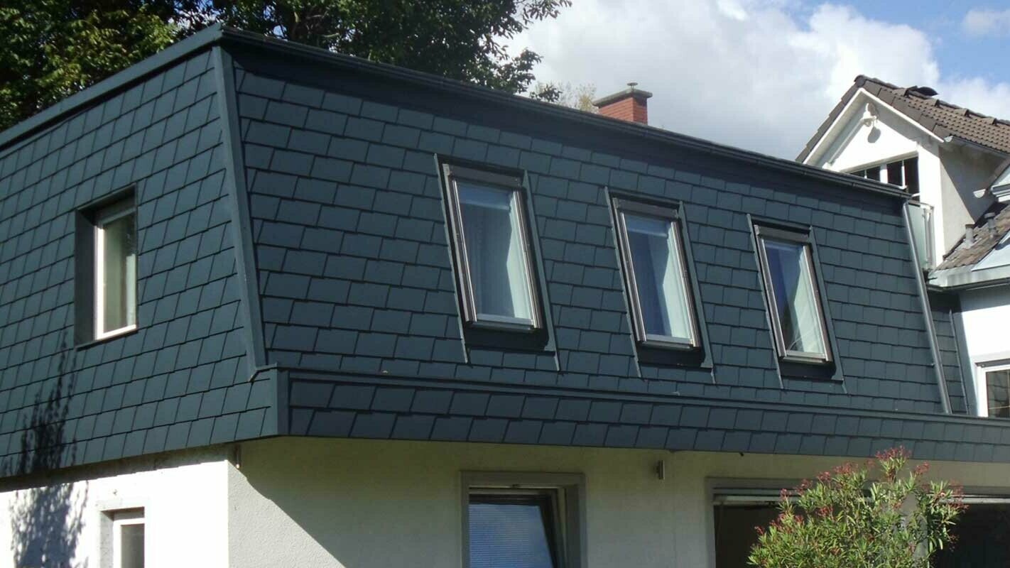 Aménagement de toit à l’aide de bardeaux de toiture PREFA, ajout d’une nouvelle structure moderne couleur anthracite, nombreuses fenêtres