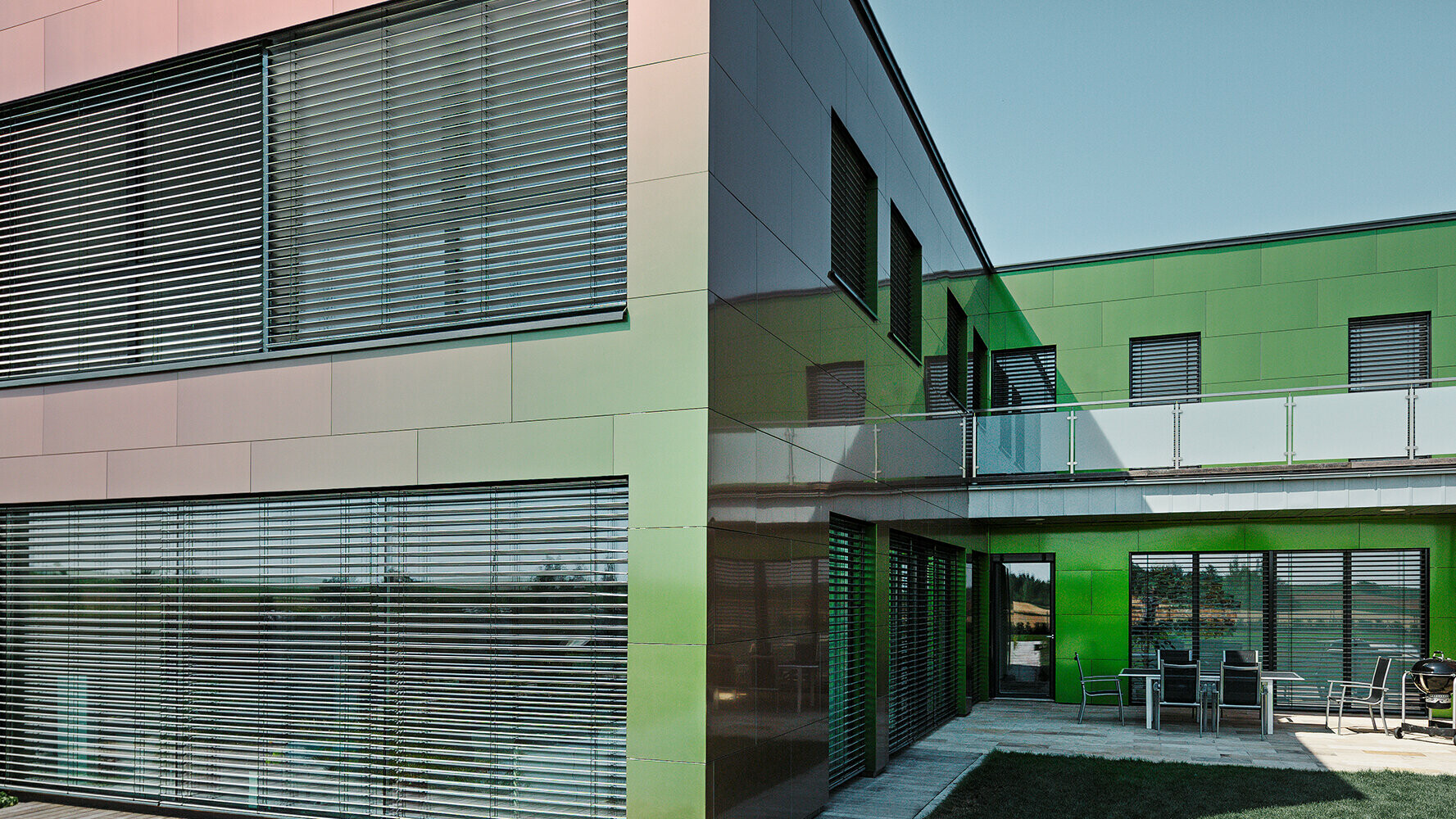 Selon la lumière et la perspective, la façade revêtue de panneaux composites de cette maison apparaît en brun, vert ou violet foncé.