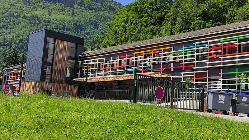 Vue éloignée de l'écolée rénovée et du gazon bien vert de l'école de Saint-Jeoire avec les Siding.X PREFA