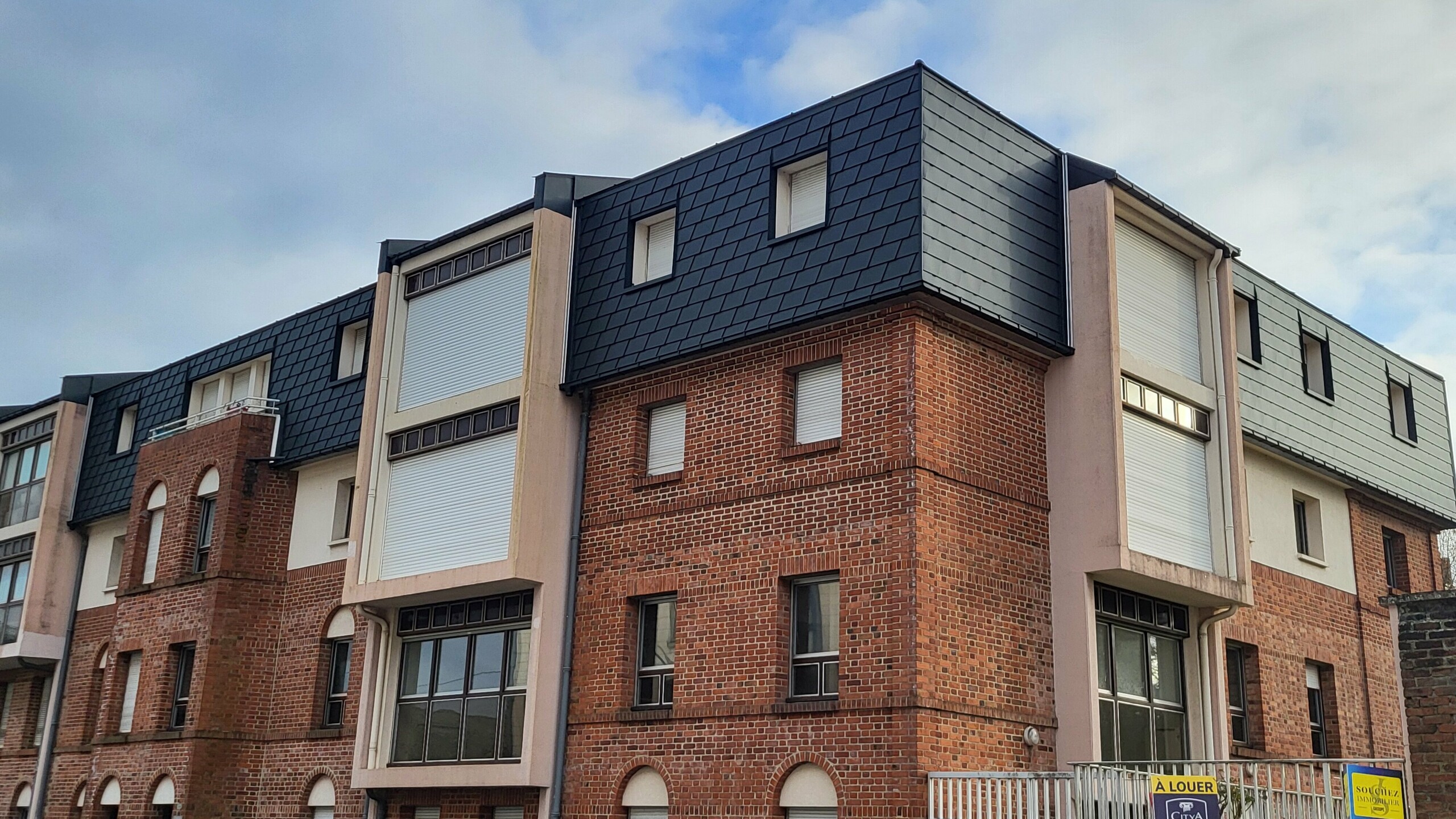 Vue d'ensemble de cette résidence située à Arras dont la toiture a été rénovée en FX.12 et bardeaux PREFA