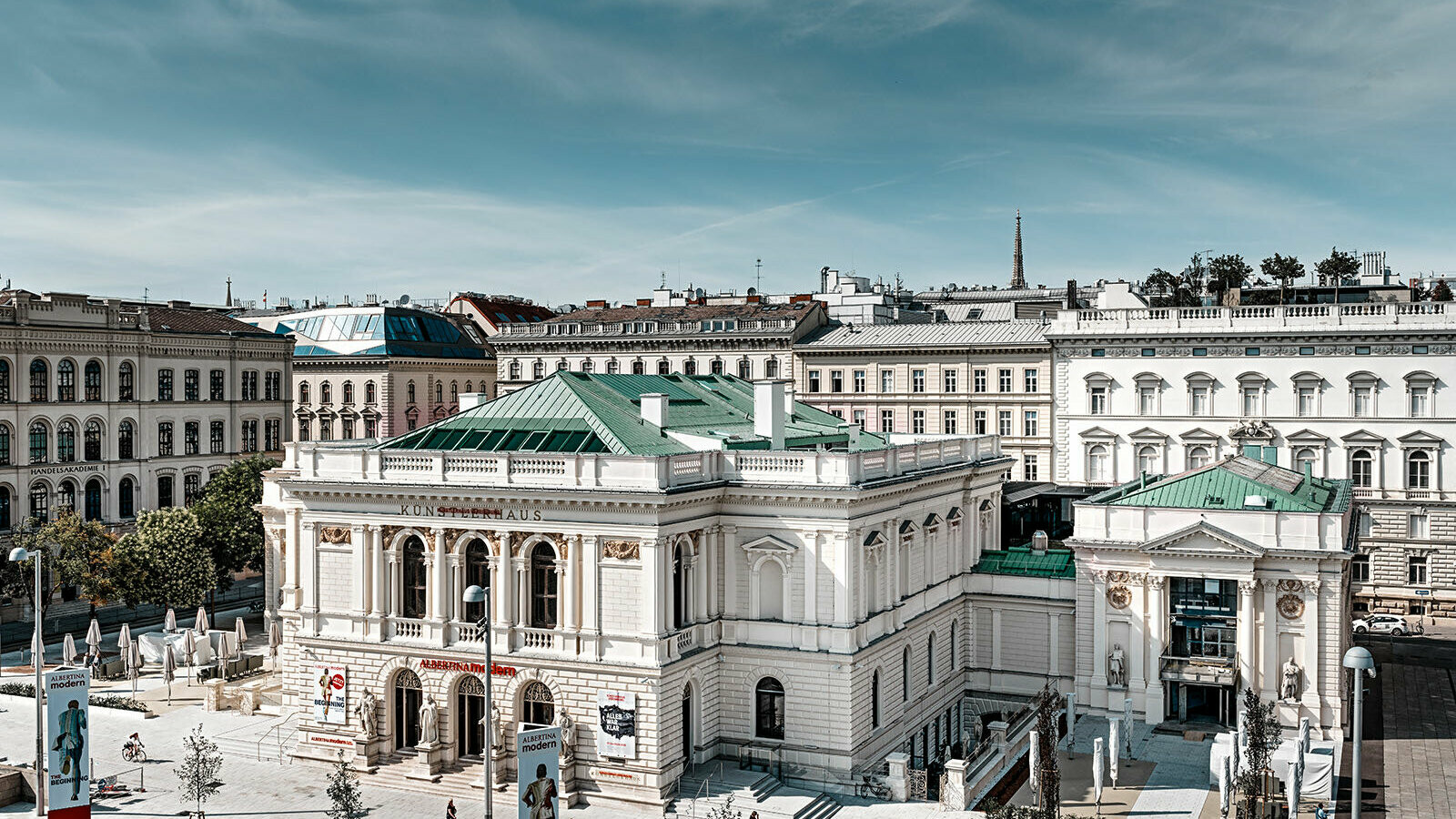 Es ist das Künstlerhaus in Wien zu sehen, umgeben von anderen Gebäuden.