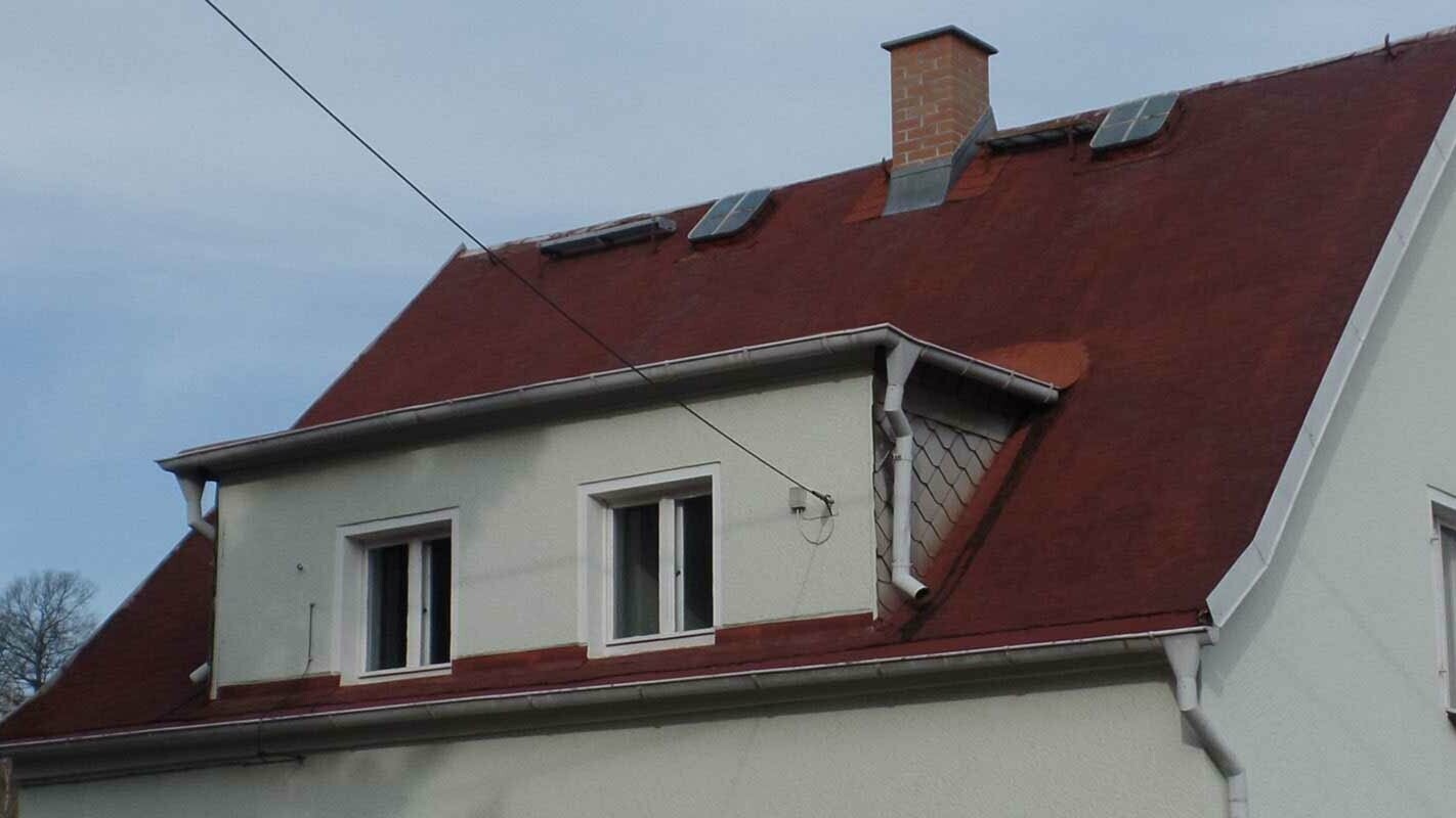 Bâtiments avec lucarne rampante, avant la rénovation à l’aide de bardeaux de toiture PREFA