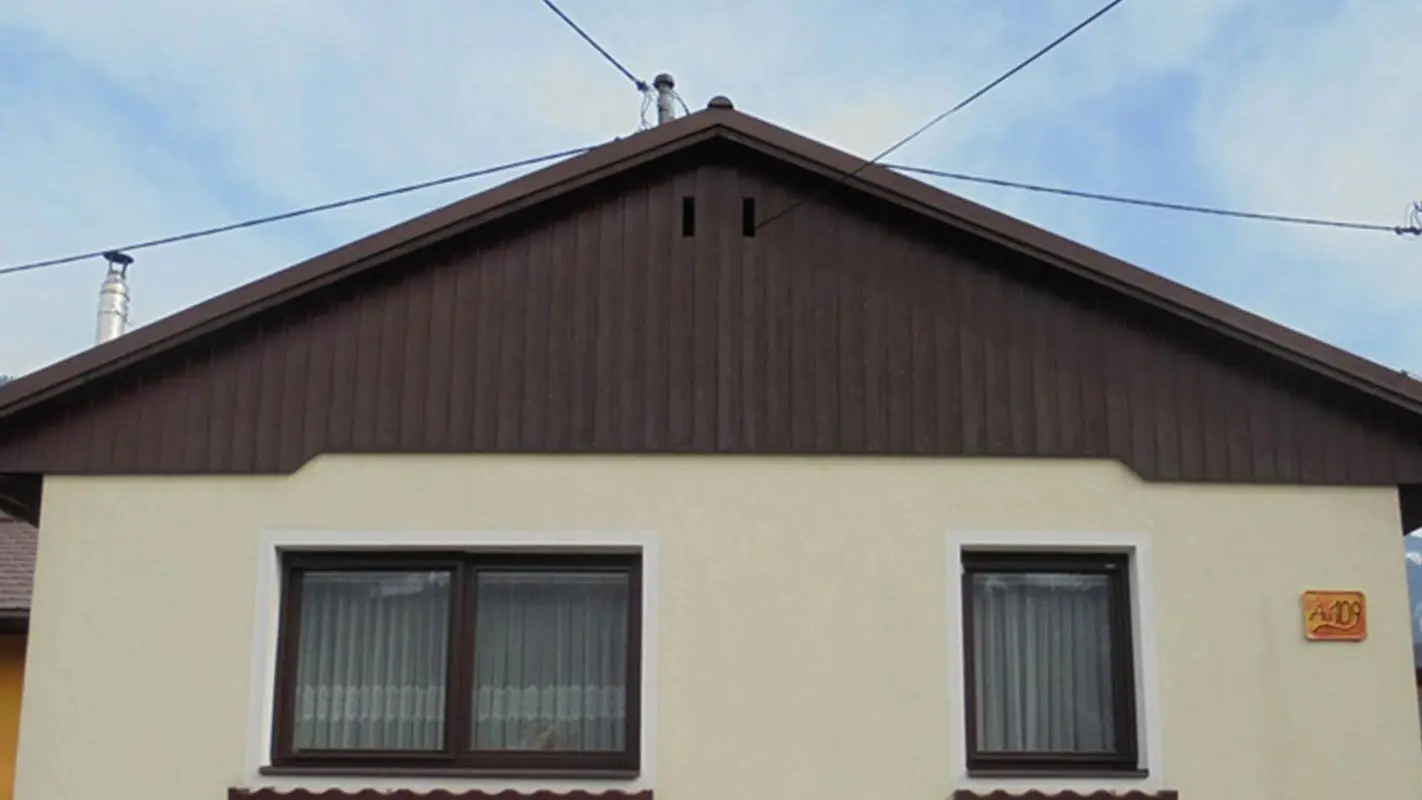 Avant la rénovation de façade du pignon à l’aide de Sidings PREFA, façade en crépi jaune, bois abîmé par le temps