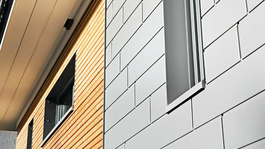 Combinaison de Sidings PREFA en aluminium couleur gris aluminium avec une façade en bois. Pose horizontale, joints décalés.