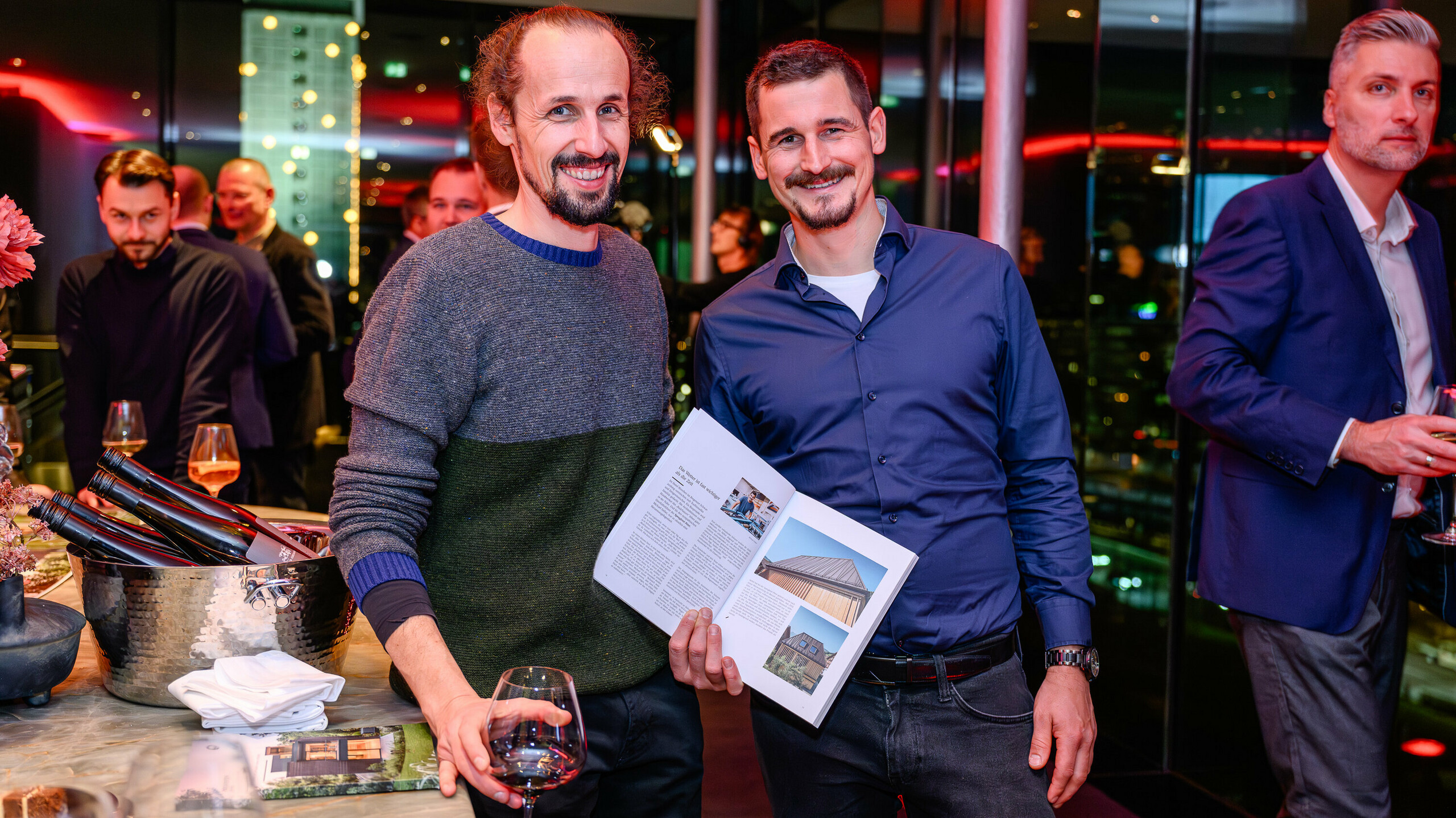 Visages rayonnants lors de la présentation PREFARENZEN 2026 : deux participants au projet présentent fièrement leur réalisation dans le nouveau livre d’architecture PREFA. La villa photographiée allie l’aspect naturel du bois à PREFALZ – un parfait exemple de contraste de matériaux modernes et d’esthétique intemporelle. L’événement au k47.wien réunit design, architecture et réseautage au plus haut niveau. Les produits en aluminium PREFA y démontrent toute leur robustesse : résistants aux intempéries, d’une grande polyvalence créative et précurseurs pour les projets de construction d’avenir. Une soirée placée sous le signe de la fierté, des échanges et de l’innovation.