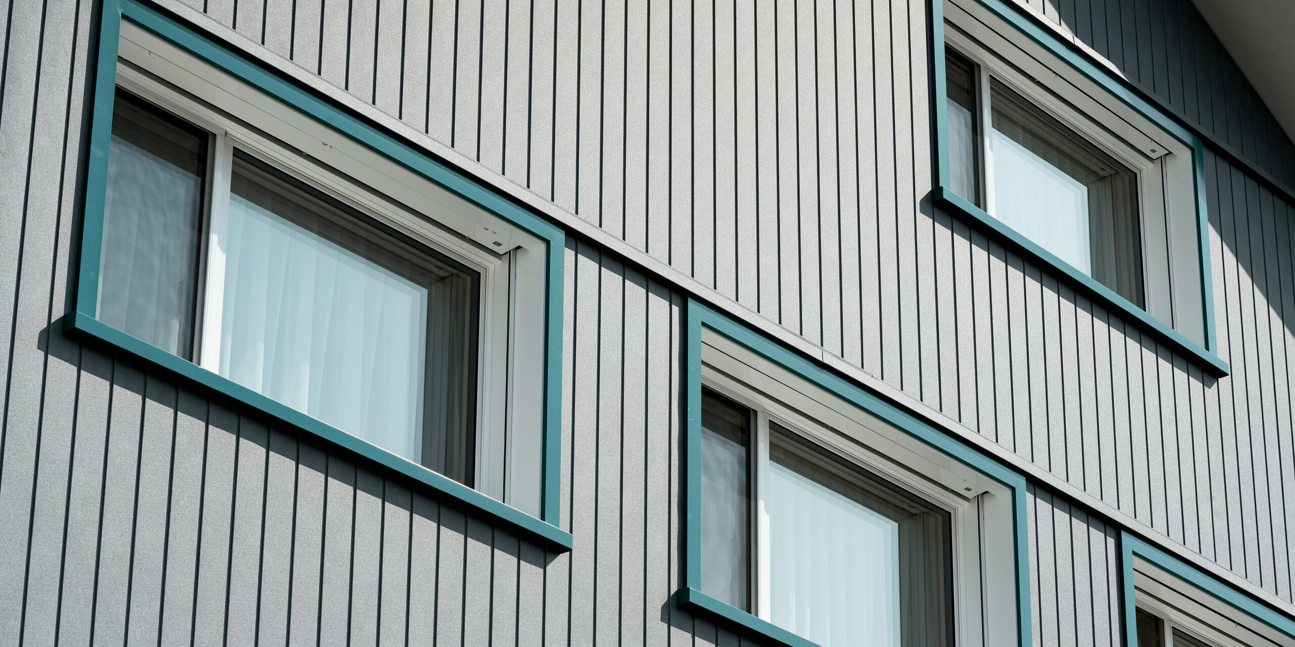 Sidings PREFA en gris pierre P.10 et blanc Prefa P.10 sur les façades de deux immeubles d'habitation voisins à Weissbad, en Suisse.