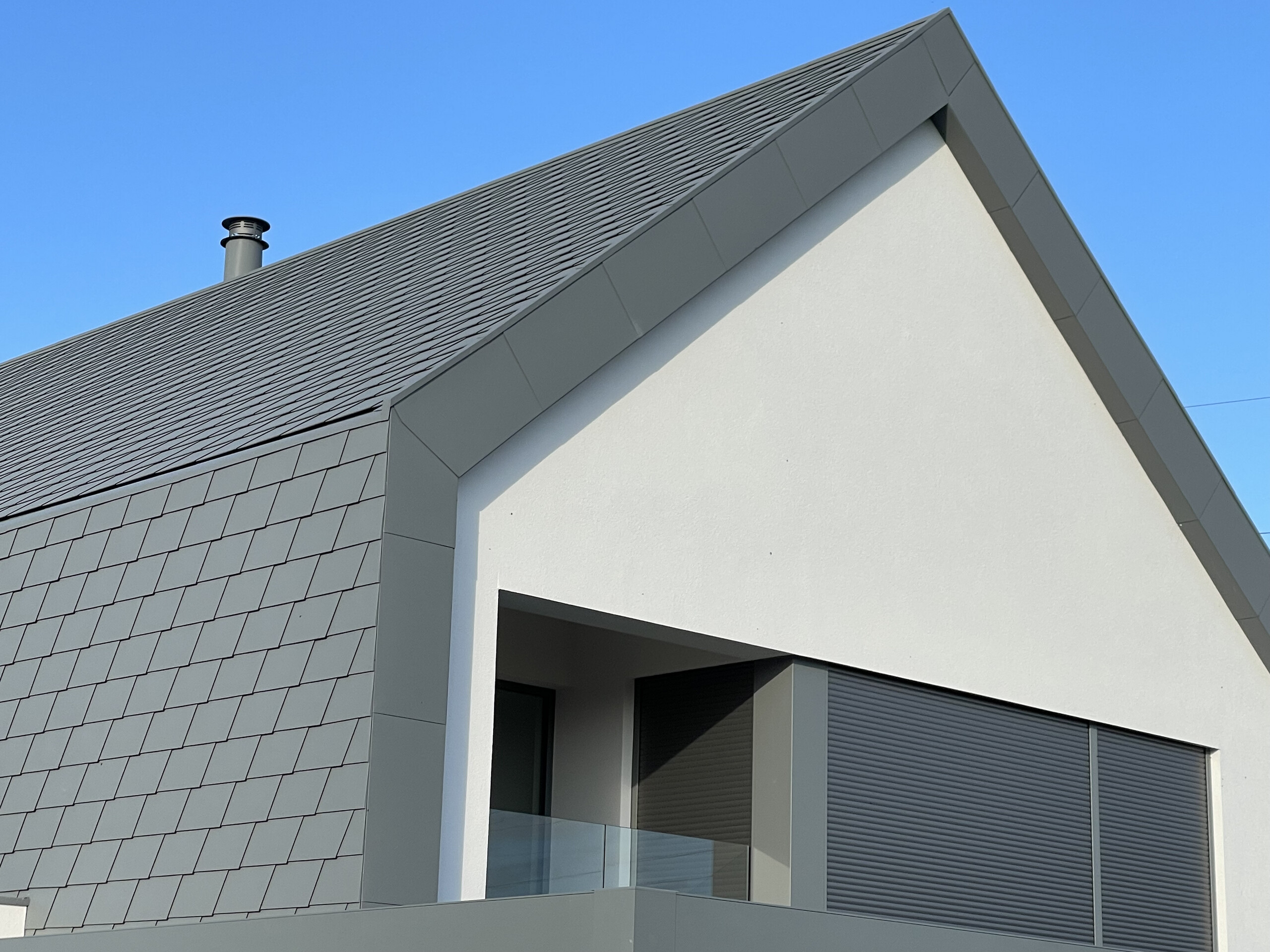 Vue de côté de cette maison contemporaine de Niederhausbergen. On voit la manière dont la toiture continue vers la façade et la netteté de l'angle et des rives.