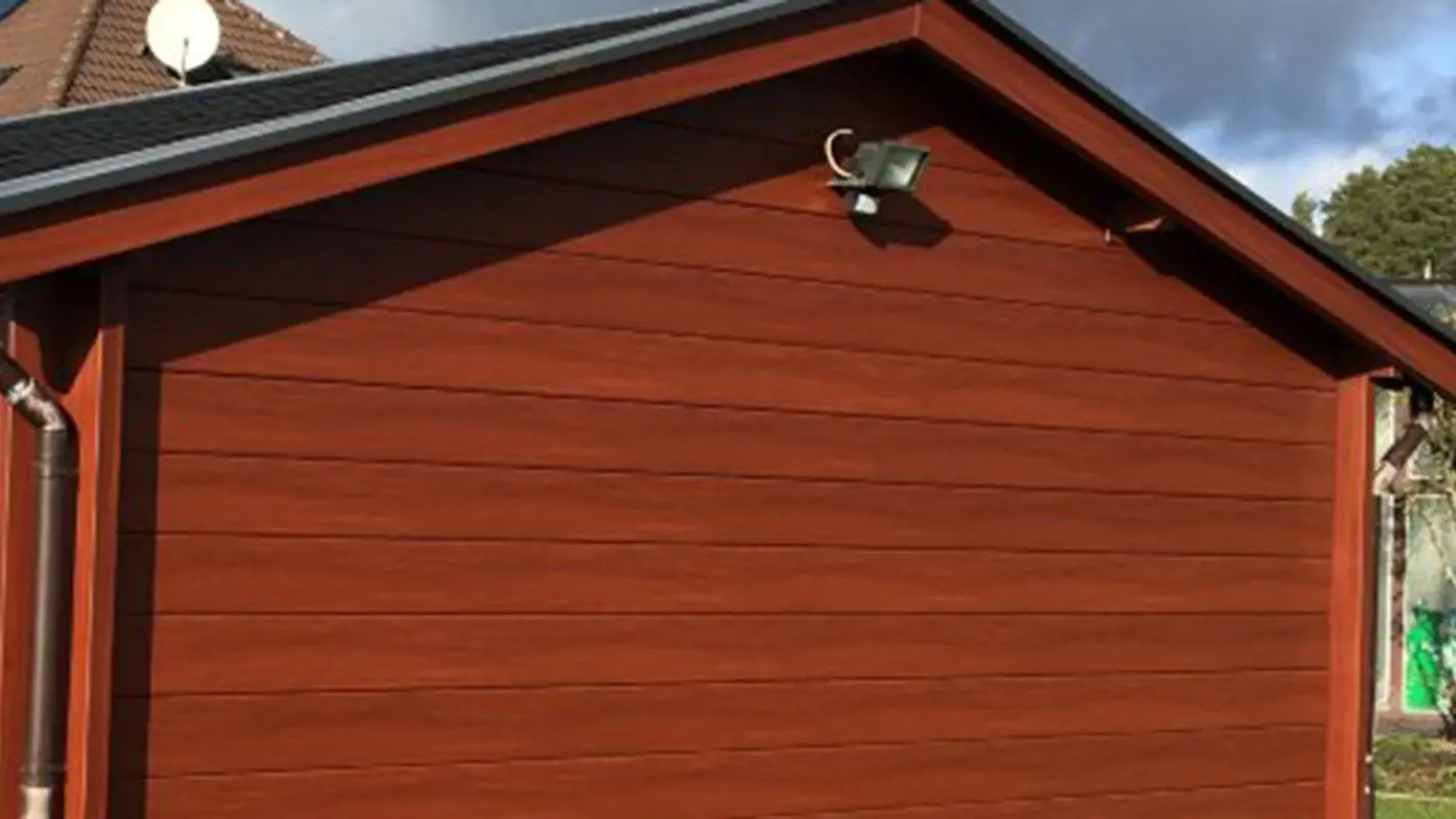 Abri de jardin rénové, avec un nouveau revêtement mural imitation bois, auparavant recouvert de bois, maintenant avec Sidings PREFA couleur bois