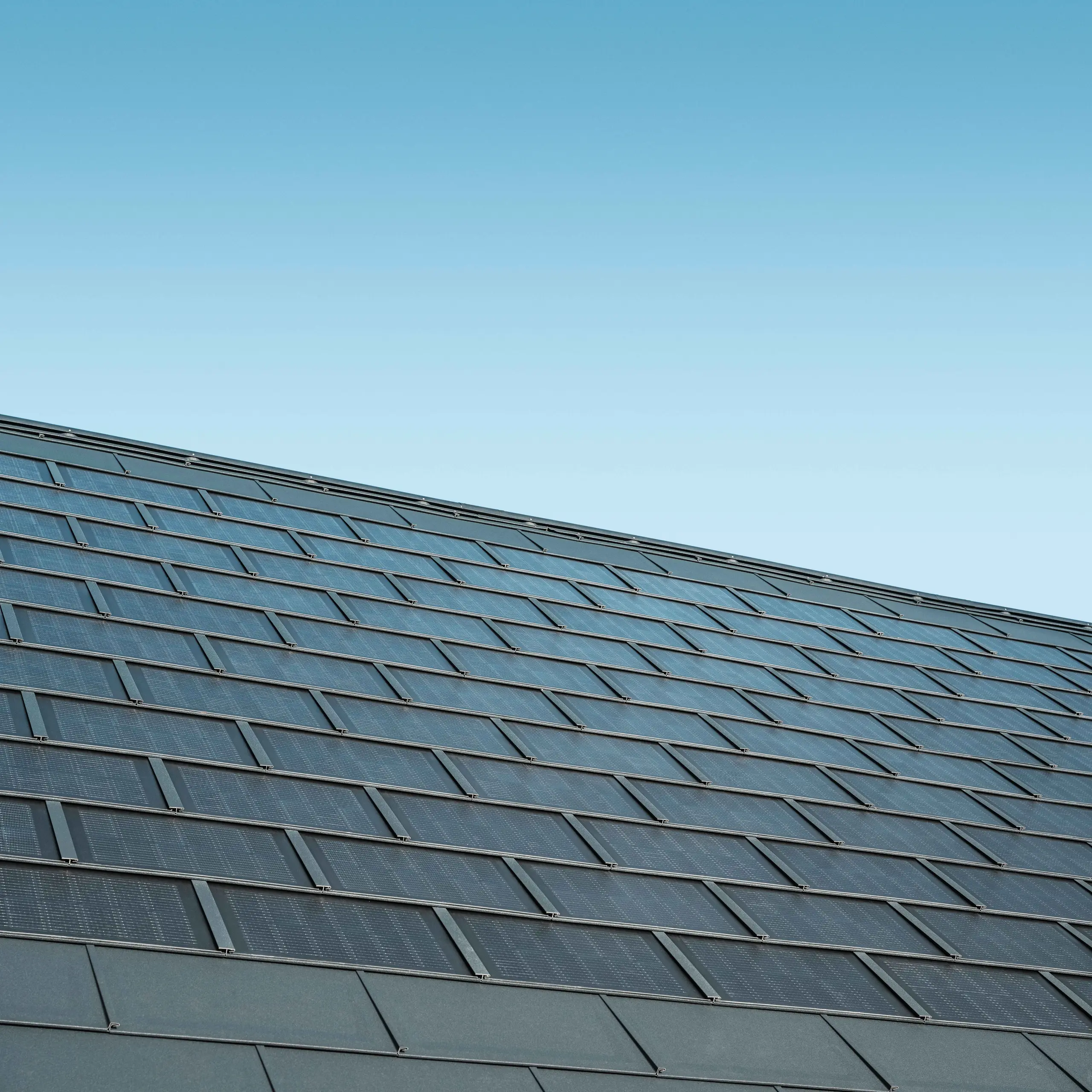 Photo d'une surface recouverte de tuiles solaires couleur anthracite, combinées au R.16