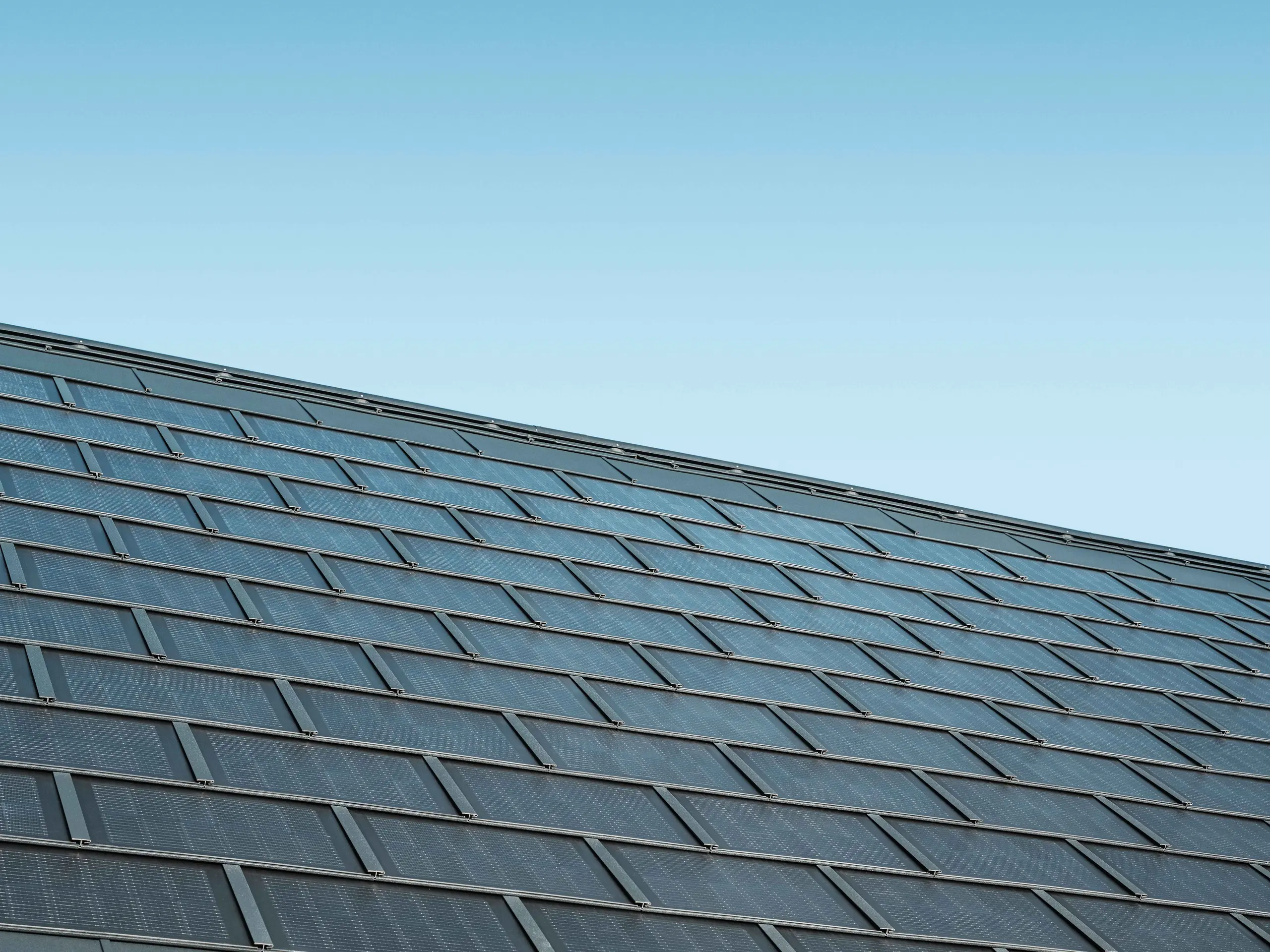 Photo d'une surface recouverte de tuiles solaires couleur anthracite, combinées au R.16