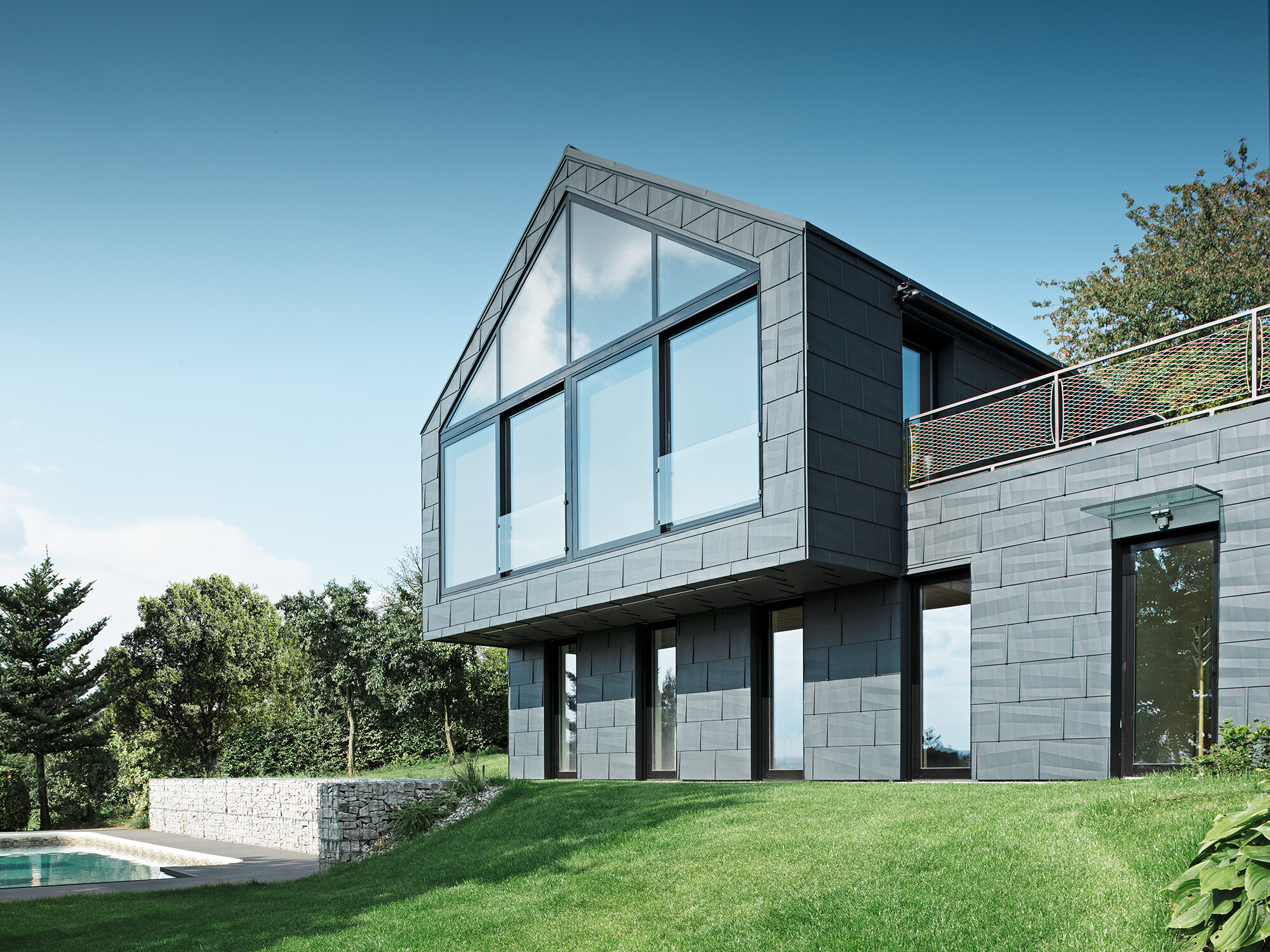 Panneaux de toiture et de façade FX.12 PREFA en P.10 anthracite à midi En milieu de journée : Revêtement mural extérieur avec FX.12 en P.10 anthracite
