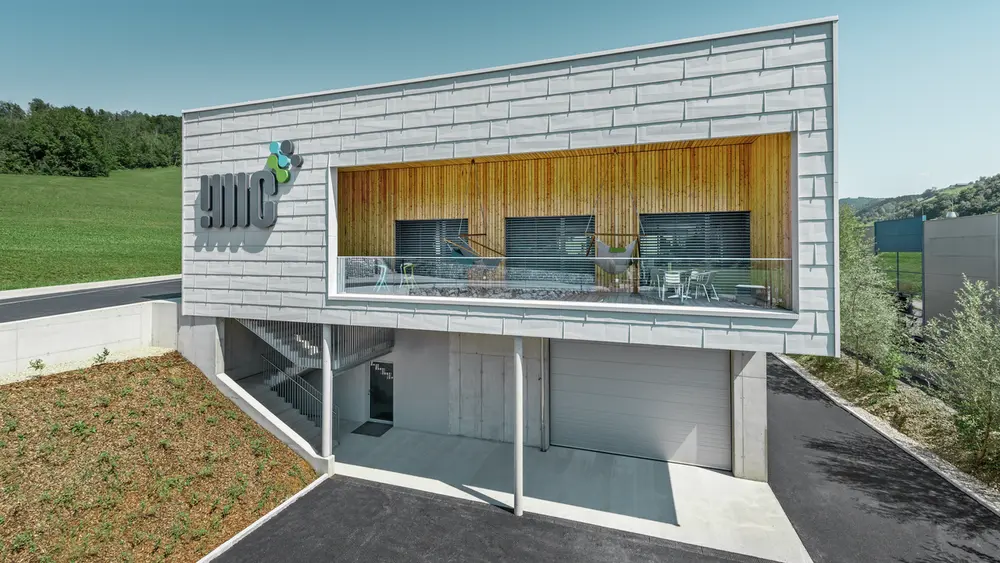 Bâtiment de société à Ybbsitz avec toit plat et façade en alu ventilée de PREFA, avec le panneau de façade FX.12 couleur blanc PREFA ;