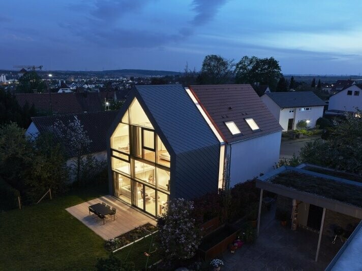 Vue de côté de la Maison J à Stuttgart (Allemagne). On aperçoit un ciel nuageux en arrière-plan. La Maison J a été recouverte de Losanges de toiture 29x29 dans la teinte P.10 gris souris.