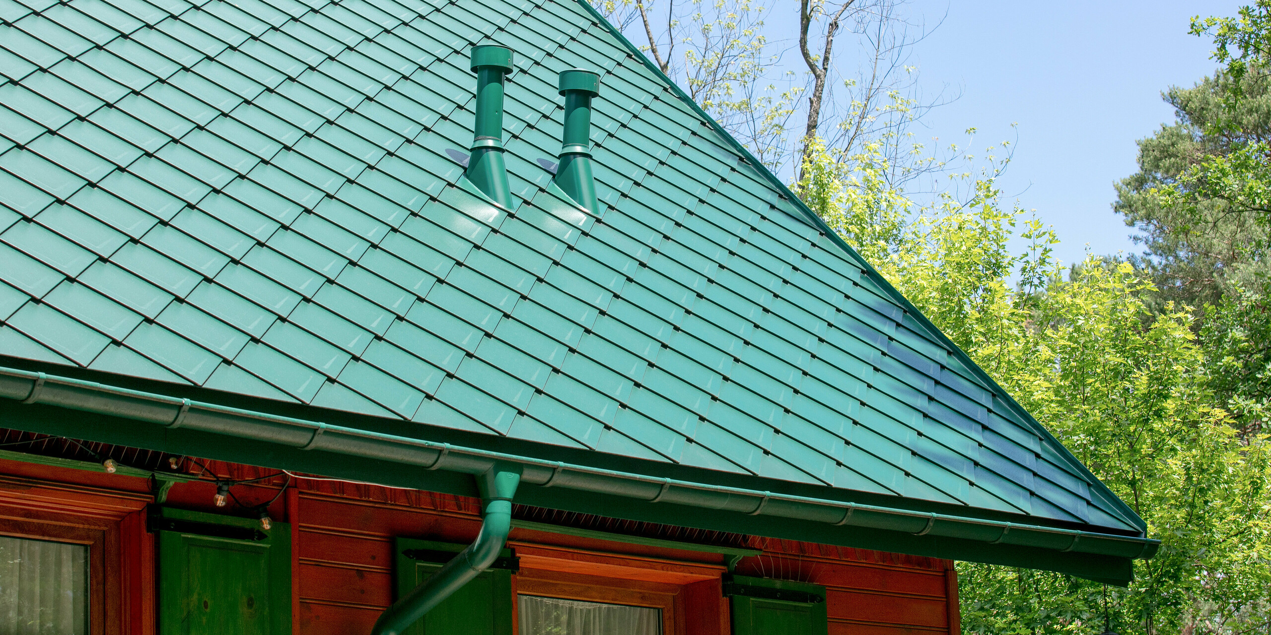 Cukiernia Sosenka avec un toit PREFA en losange 44×44 ainsi que tuyau de descente et gouttière suspendue en vert mousse