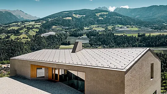 Le centre éducatif de Riffian, dans le Tyrol du Sud, se distingue par une architecture moderne intégrant des losanges de toiture PREFA 44 × 44 en finition P.10 Bronze. Cette toiture en aluminium, caractérisée par sa grande durabilité, s'intègre harmonieusement au paysage montagneux ; elle séduit par la précision de sa réalisation et assure une protection durable du jardin d'enfants et de l'école primaire contre les intempéries.